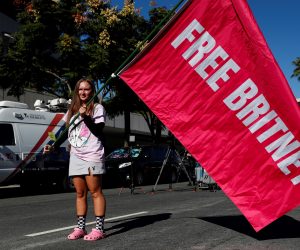 epa09579524 Alexandra Foertschbeck holds a 'Free Britney' flag during a rally outside a hearing concerning the US singer Britney Spears’ conservatorship at the Stanley Mosk Courthouse in Los Angeles, California, USA, 12 November 2021.  EPA/CAROLINE BREHMAN