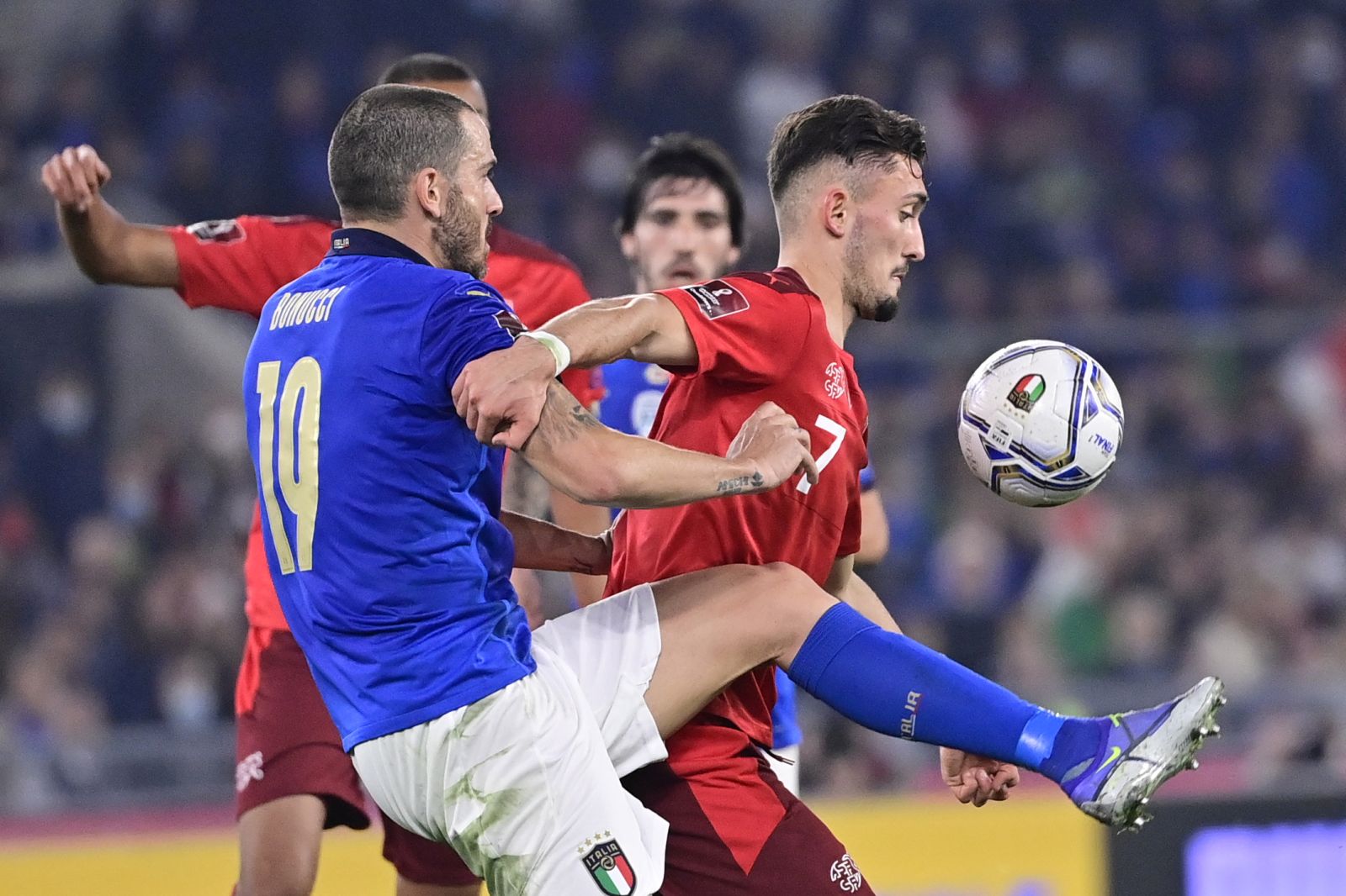 epa09579592 Italy's defender Leonardo Bonucci (L) fights for the ball against Switzerland's forward Andi Zeqiri during the 2022 FIFA World Cup European Qualifying Group C match between Italy and Switzerland at the Stadio Olimpico in Rome, Italy, 12 November 2021.  EPA/JEAN-CHRISTOPHE BOTT
