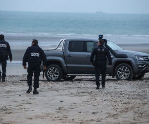 epa09602233 Policemen inspect the beach near Wimereux, France, 25 November 2021. At least 27 migrants have died and two others have been taken to hospital after a boat in which they were trying to cross the La Manche canal (English Channel) to Great Britain sank on 24 November.  EPA/MOHAMMED BADRA
