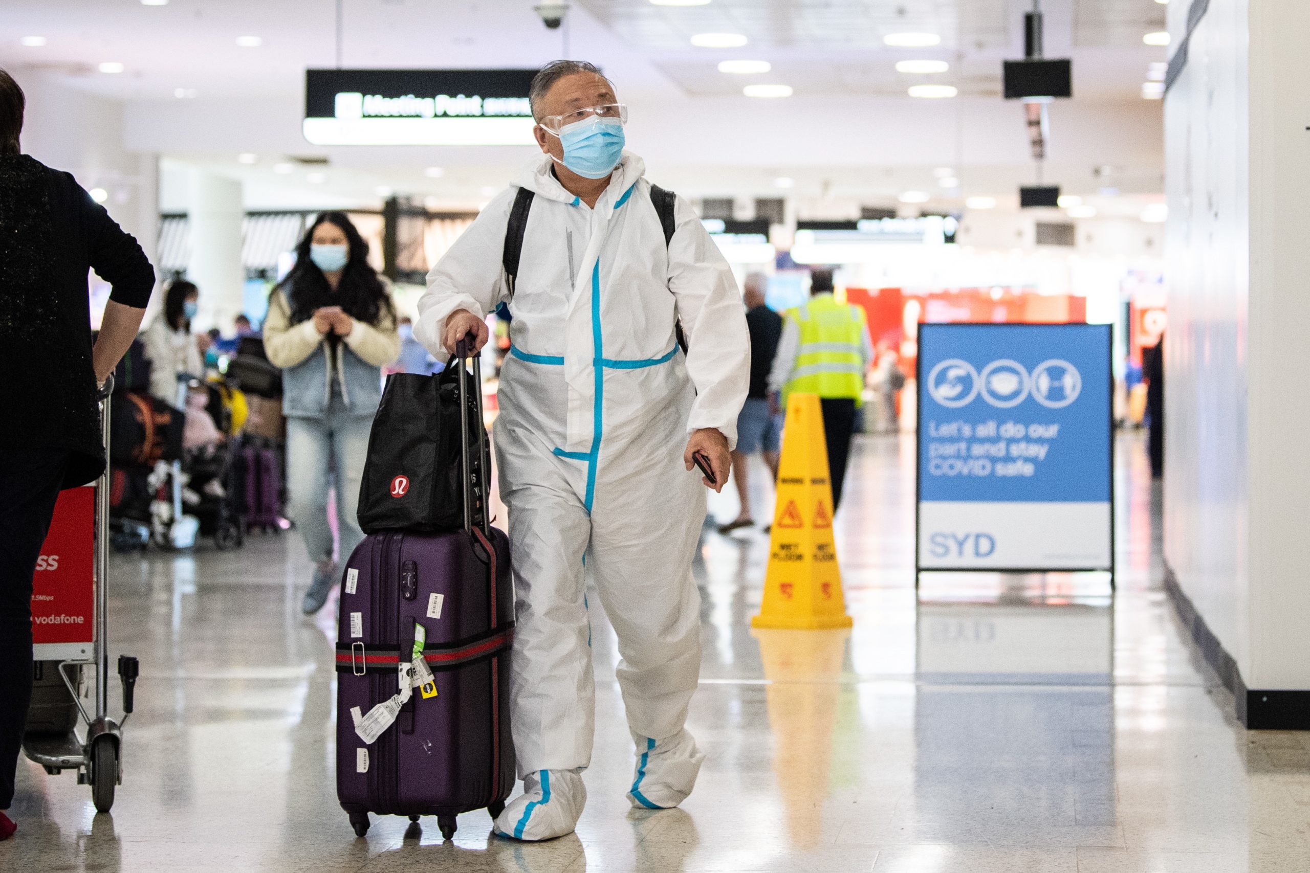 epa09610680 Travelers wearing personal protective equipment (PPE) arrive at Sydney International Airport in Sydney, New South Wales (NSW), Australia, 29 November 2021. The Omicron variant of SARS-CoV-2, the virus that causes COVID-19, has arrived in Australia after testing confirmed two overseas travellers who arrived in Sydney were infected with the new strain.  EPA/JAMES GOURLEY  AUSTRALIA AND NEW ZEALAND OUT
