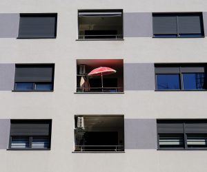 09.04.2020., Zagreb - Usamljeni crveni suncobran na balkonu moderne stambene zgrade. 
Photo: Tomislav Miletic/PIXSELL