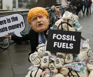 A person wears a mask depicting Britain's Prime Minister Boris Johnson during a protest at the UN Climate Change Conference (COP26) in Glasgow, Scotland, Britain November 12, 2021. REUTERS/Russell Cheyne