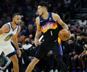 Phoenix Suns guard Devin Booker (1) defended by Golden State Warriors guard Stephen Curry (30) during the first half of an NBA basketball game, Tuesday, Nov. 30, 2021, in Phoenix. (AP Photo/Matt York)