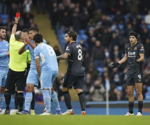 Wolverhampton Wanderers' Raul Jimenez, right, receives a red card from referee Jonathan Moss during the English Premier League soccer match between Manchester City and Wolverhampton Wanderers, at the Etihad stadium in Manchester, England, Saturday, Dec.11, 2021. (AP Photo/Dave Thompson)