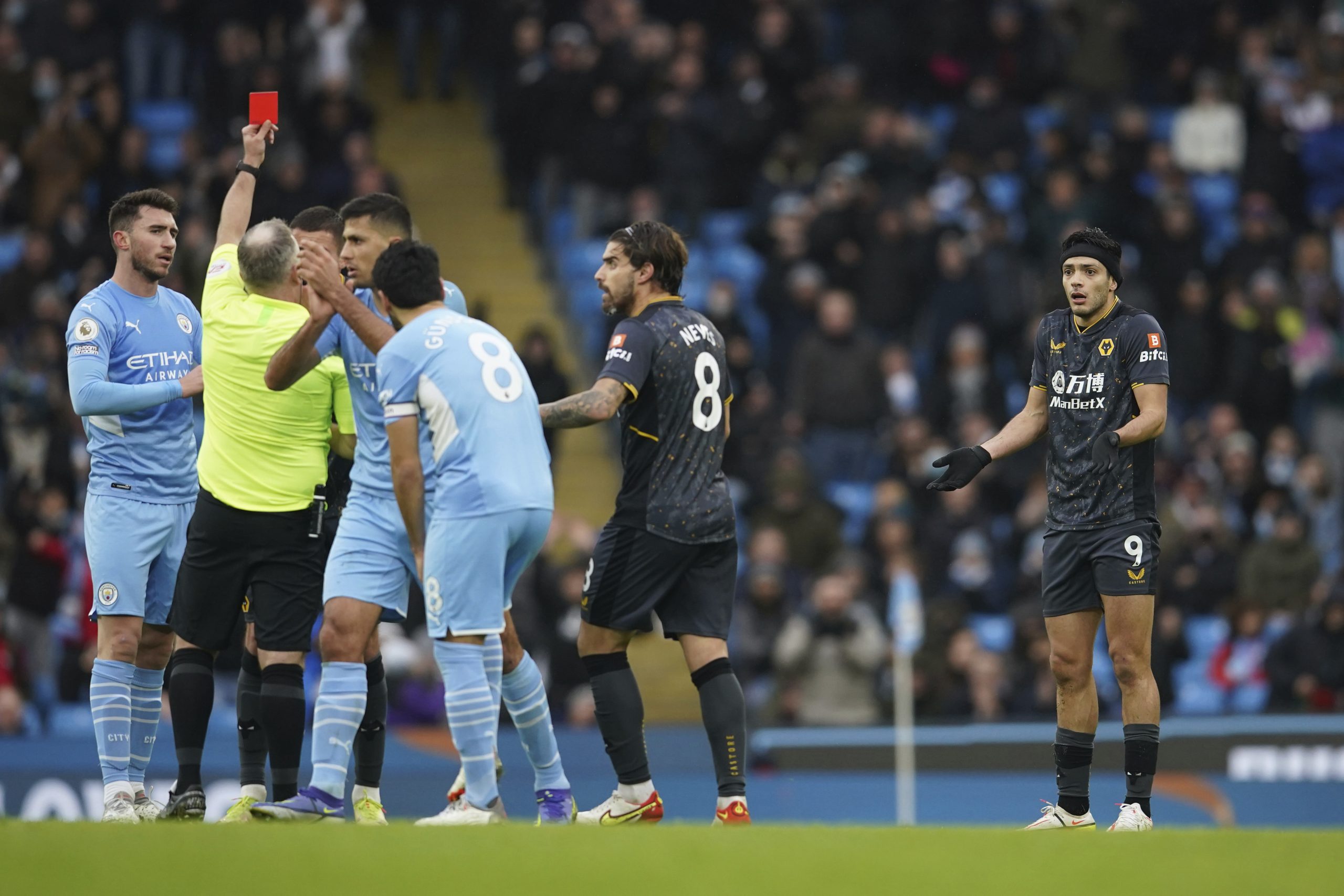 Wolverhampton Wanderers' Raul Jimenez, right, receives a red card from referee Jonathan Moss during the English Premier League soccer match between Manchester City and Wolverhampton Wanderers, at the Etihad stadium in Manchester, England, Saturday, Dec.11, 2021. (AP Photo/Dave Thompson)