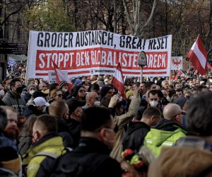 epa09593377 Protesters display a banner reading 'Grosser Austausch, great Reset Stoppt den Globalistendreck' ('Great exchange, Great Reset, Stop the globalist filth') during a demonstration against the measures of the Austrian government to slow down the ongoing pandemic of the COVID-19 disease caused by the SARS-CoV-2 coronavirus in Vienna, Austria, 20 November 2021. Austrian Chancellor Alexander Schallenberg announced a mandatory vaccination against the SARS-CoV-2 coronavirus by February 2022, and a general nationwide lockdown to stem the ongoing pandemic of COVID-19, starting from 22 November.  EPA/CHRISTIAN BRUNA