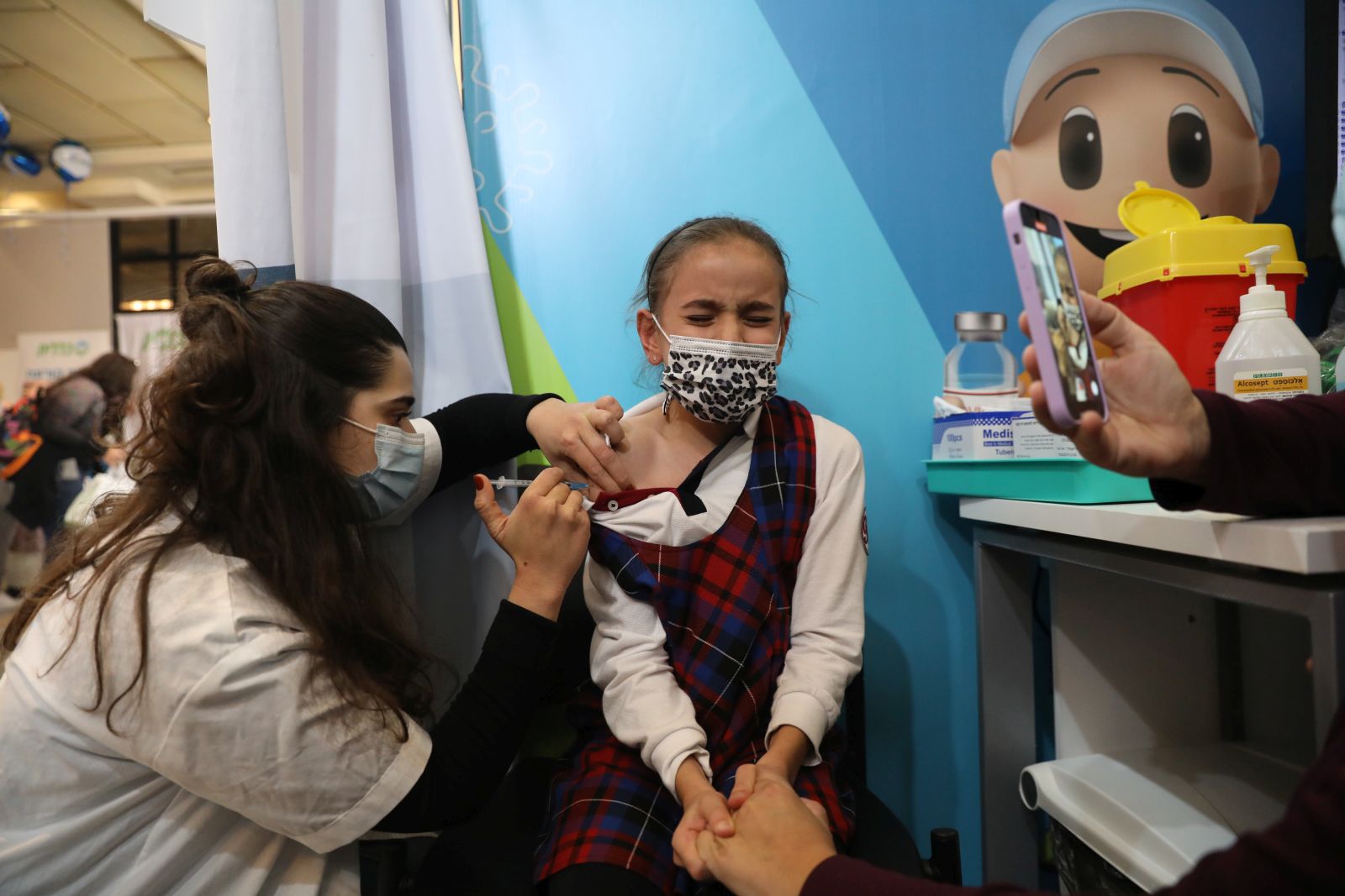 epa09598875 A nurse injects a child with a first shot of a COVID-19 vaccine in Jerusalem, Israel, 23 November 2021. Israel launched a campaign to offer Covid-19 vaccine dose for children between 5 and 12 years old  EPA/ABIR SULTAN