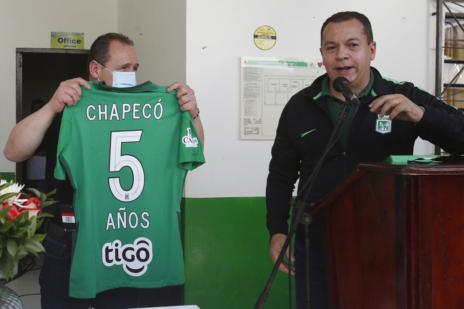 epa09610150 The mayor of the municipality of La Union, Edgar Alexander Osorio (L), receives a commemorative Atletico Nacional shirt from the human talent manager, Alfonso Leon Ossa, during a tribute to the victims of the accident of the Brazilian soccer team Chapecoense, in the village of Pantalio de La Union, Colombia, 28 November 2021. Five years ago Brazil woke to a sports tragedy, the Chapecoense plane crashed near Medellin. Five years without justice and with a 'feeling of impunity' that still saddens, as former player Helio Neto, one of the six survivors, told Efe.  EPA/Luis Eduardo Noriega A.