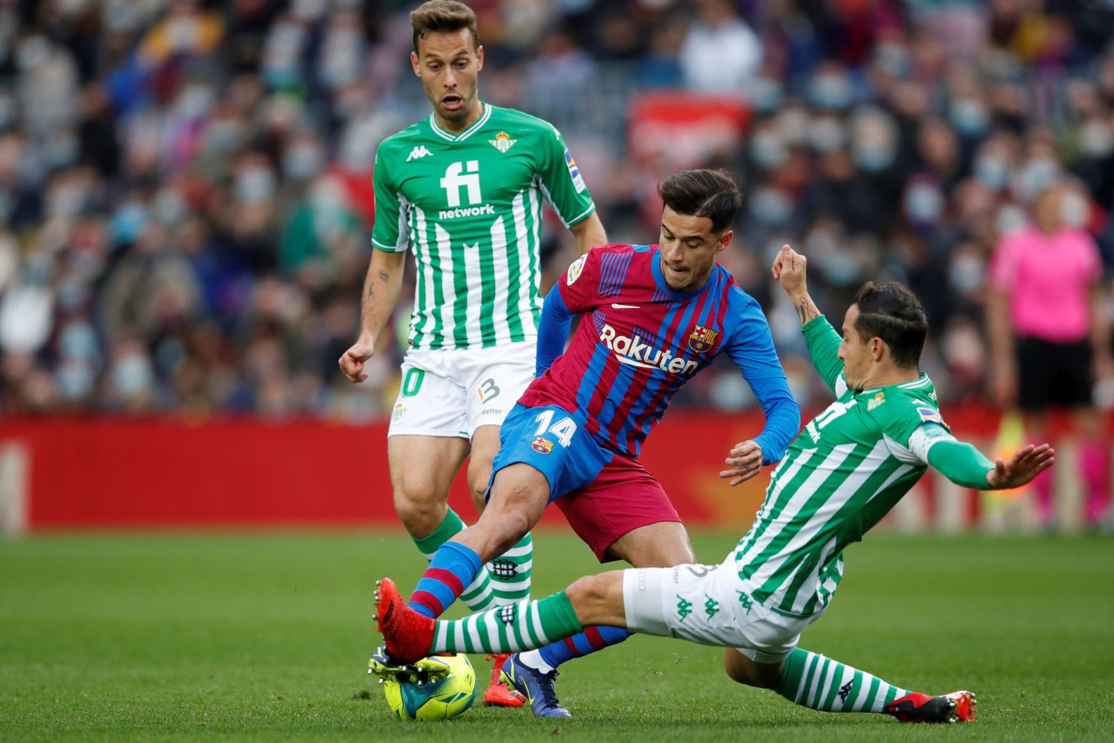 epa09621262 FC Barcelona's Philippe Coutinho (C) in action against Betis' Sergio Canales (L) and Andres Guardado (R) during their Spanish LaLiga soccer match between FC Barcelona and Real Betis Balompie at Camp Nou stadium in Barcelona, Catalonia, Spain, 04 December 2021.  EPA/Alejandro Garcia