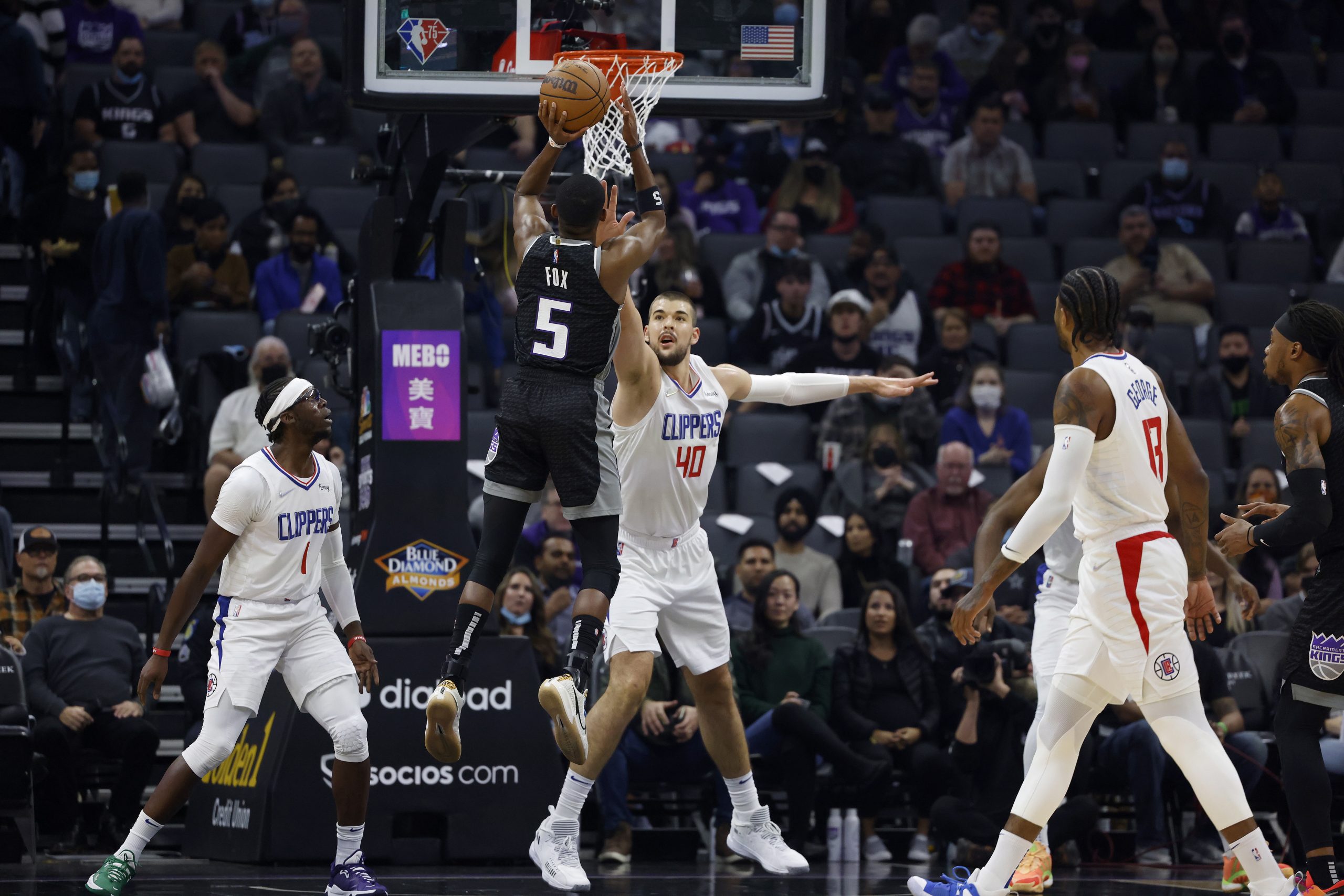 epa09622880 Sacramento Kings guard De'Aaron Fox (2-L) shoots a two point basket as LA Clippers center Ivica Zubac (C) defends during the first half of their NBA game at the Golden 1 Center in Sacramento, California, USA, 04 December 2021.  EPA/JOHN G. MABANGLO  SHUTTERSTOCK OUT