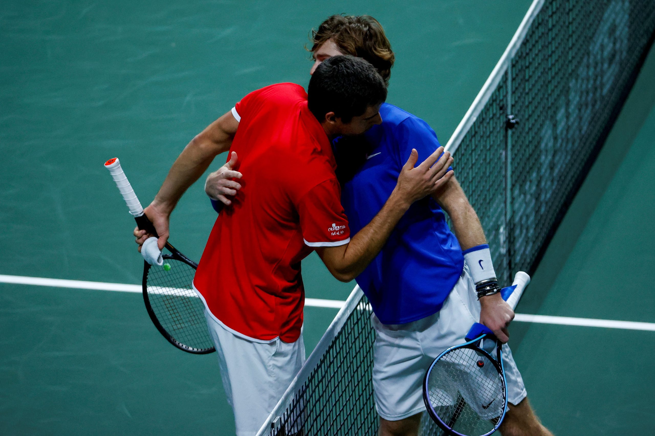 epa09624273 Andrey Rublev (R) of Russia is congratulated by Borna Gojo (L) of Croatia after winning their singles match during the Davis Cup Final between Russia and Croatia in Madrid, Spain, 05 December 2021.  EPA/Emilio Naranjo