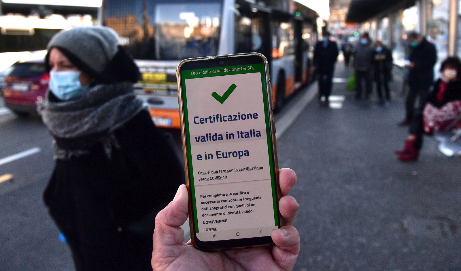 epa09625357 A valid Green Pass for Italy and EU the is diplayed on a smartphone while Italian Police and staff of AMT are checking the QR code confirming that people received the Covid-19 vaccine, at Brignole bus stop in Genoa, Italy, 06 December 2021. The measures on the 'enhanced' green certificate (obtainable only with vaccination or recovery) come into effect from 06 December 2021 until 15 January 2022.  EPA/LUCA ZENNARO