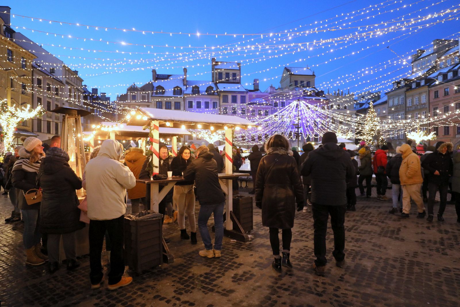 epa09657371 People visit Christmas market stands next to an ice rink at the Old Town Square in Warsaw, Poland, 26 December 2021, on the second day of the Christmas holidays.  EPA/PAWEL SUPERNAK POLAND OUT