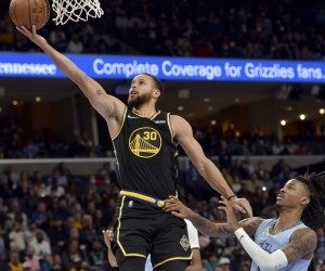 Golden State Warriors guard Stephen Curry (30) shoots the ball ahead of Memphis Grizzlies guard Ja Morant in the first half of an NBA basketball game Tuesday, Jan. 11, 2022, in Memphis, Tenn. (AP Photo/Brandon Dill)