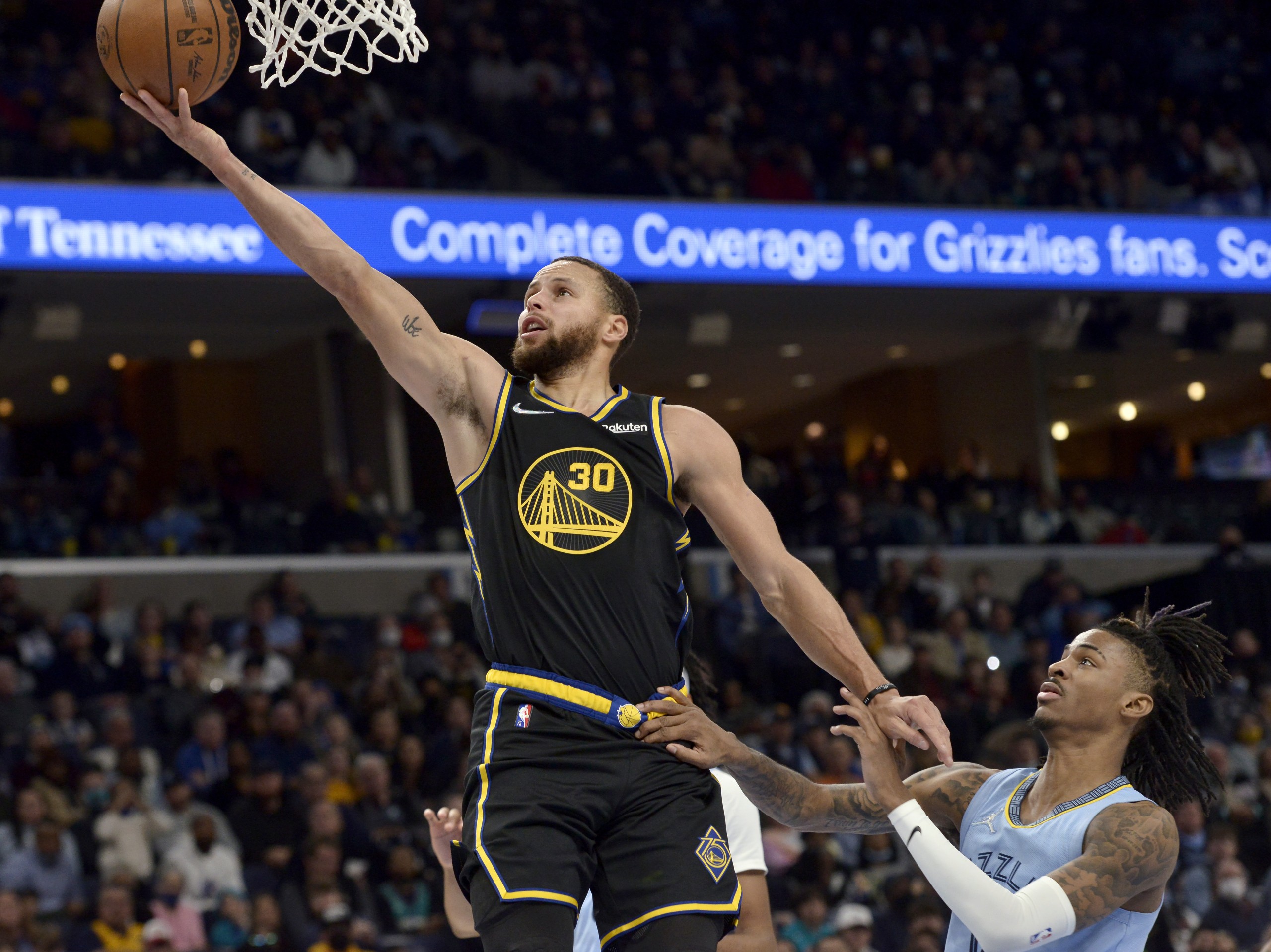 Golden State Warriors guard Stephen Curry (30) shoots the ball ahead of Memphis Grizzlies guard Ja Morant in the first half of an NBA basketball game Tuesday, Jan. 11, 2022, in Memphis, Tenn. (AP Photo/Brandon Dill)