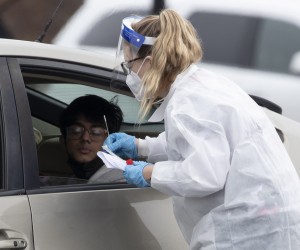 epa09660734 A Covid-19 test is administered to an individual inside a vehicle at the head of a long line at a Covid-19 drive-thru testing event in Leesburg, Virginia, USA, 30 December 2021. The Loudoun County government held a free drive-thru Covid-19 testing event that reached maximum capacity ahead of schedule, drawing hundreds of vehicles that formed a line well over a mile long with wait times over two hours for some people.  EPA/MICHAEL REYNOLDS