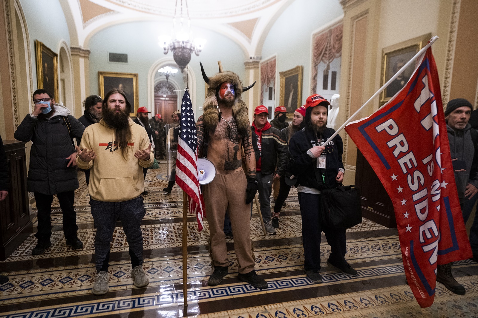 epa09664285 (14/24) (FILE) - Supporters of US President Trump stand by the door to the Senate chambers after they breached the US Capitol security in Washington, DC, USA, 06 January 2021 (reissued 03 January 2021). Following the November 2020 US presidential election, a tone set by supporters of defeated US President Donald Trump escalated further. Trump, who was refusing to concede the victory of Joe Biden, claiming voter fraud and rigged elections, told supporters and white nationalist extreme-right group Proud Boys to respectively 'Stop the Steal' and to 'stand back and stand by'. His social media accounts were suspended and the alt-right platform Parler gained in user numbers. 
 
On 06 January 2021, incumbent US vice president Pence was due to certify the Electoral College votes before Congress, the last step in the process before President-elect Biden was to be sworn in. In the morning, pro-Trump protesters had gathered for the so-called Save America March. Soon after Trump finished his speech at the Ellipse, the crowd marched to the Capitol. The attack had begun. 
 
Rioters broke into the Capitol building where the joint Congress session was being held. Lawmakers barricaded themselves inside the chambers and donned tear gas masks while rioters vandalized the building, some even occupying offices such as House Speaker Pelosi's. Eventually in the evening the building was cleared from insurrectionists, and the Congress chambers reconvened their session, confirming Joe Biden as the winner of the 2020 US presidential election. 

In the aftermath, more than 600 people were charged with federal crimes in connection to the insurgency, and close Trump aides such as Steve Bannon, Mark Meadows and Roger Stone were subpoenaed by the House select committee investigating the attack. Trump himself was acquitted by the Senate in his second impeachment trial, this time for "inciting an insurrection".  EPA/JIM LO SCALZO  ATTENTION: This Image is part of a PHOTO SET *** Loc