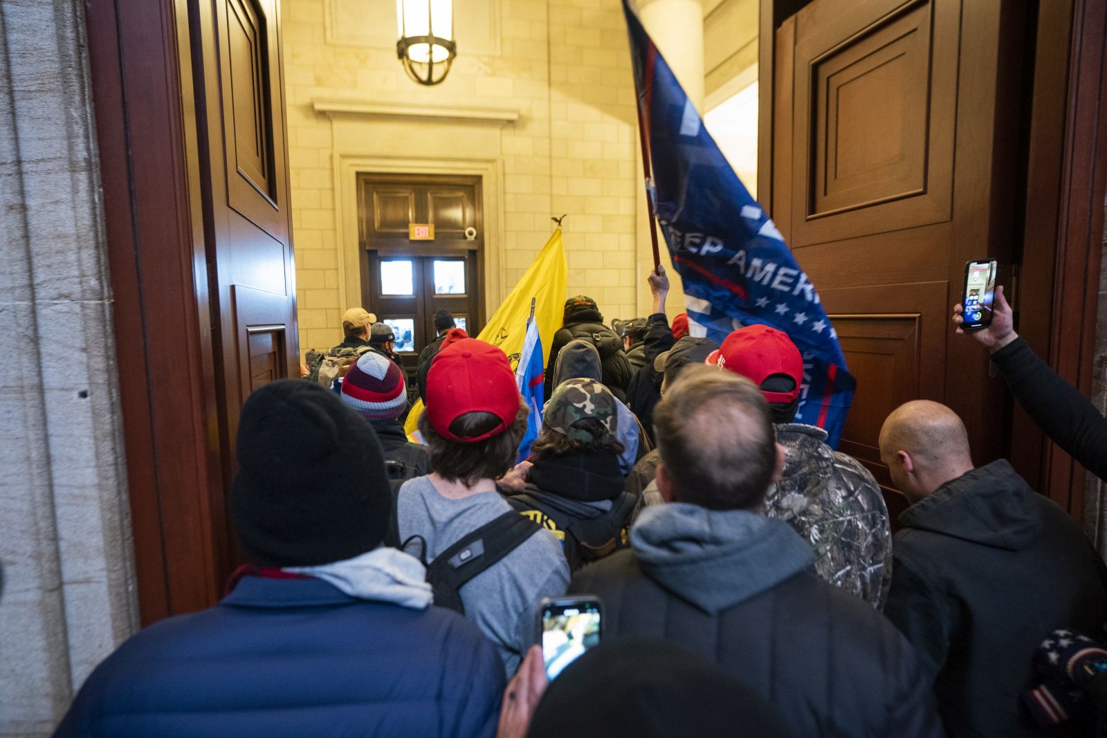 epa09664283 (12/24) (FILE) - Supporters of US President Trump stand by the door of the Eastern front after they breached the US Capitol security in Washington, DC, USA, 06 January 2021 (reissued 03 January 2021). Following the November 2020 US presidential election, a tone set by supporters of defeated US President Donald Trump escalated further. Trump, who was refusing to concede the victory of Joe Biden, claiming voter fraud and rigged elections, told supporters and white nationalist extreme-right group Proud Boys to respectively 'Stop the Steal' and to 'stand back and stand by'. His social media accounts were suspended and the alt-right platform Parler gained in user numbers. 
 
On 06 January 2021, incumbent US vice president Pence was due to certify the Electoral College votes before Congress, the last step in the process before President-elect Biden was to be sworn in. In the morning, pro-Trump protesters had gathered for the so-called Save America March. Soon after Trump finished his speech at the Ellipse, the crowd marched to the Capitol. The attack had begun. 
 
Rioters broke into the Capitol building where the joint Congress session was being held. Lawmakers barricaded themselves inside the chambers and donned tear gas masks while rioters vandalized the building, some even occupying offices such as House Speaker Pelosi's. Eventually in the evening the building was cleared from insurrectionists, and the Congress chambers reconvened their session, confirming Joe Biden as the winner of the 2020 US presidential election. 

In the aftermath, more than 600 people were charged with federal crimes in connection to the insurgency, and close Trump aides such as Steve Bannon, Mark Meadows and Roger Stone were subpoenaed by the House select committee investigating the attack. Trump himself was acquitted by the Senate in his second impeachment trial, this time for "inciting an insurrection".  EPA/JIM LO SCALZO  ATTENTION: This Image is part of a PHOTO SET *** Local