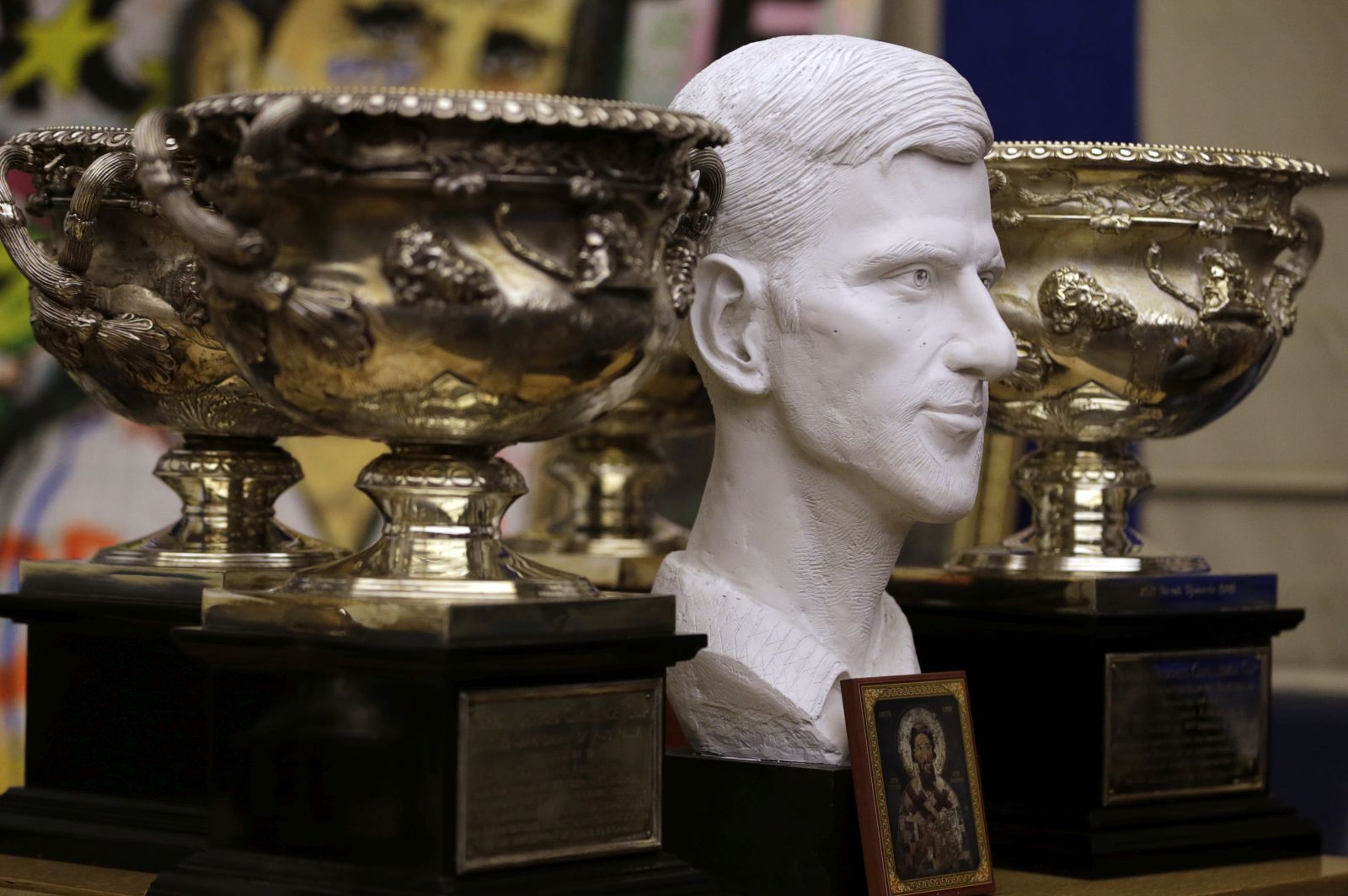 epa09676997 A bust of Novak Djokovic is surrounded with Australian Open trophies in Belgrade, Serbia, 10 January 2022. Novak Djokovic was to be released from an immigration detention center in Melbourne after an order by the Federal Circuit Court. The tennis world number one had been staying in a hotel-turned-detention center after his visa was revoked upon landing in Australia.  EPA/ANDREJ CUKIC