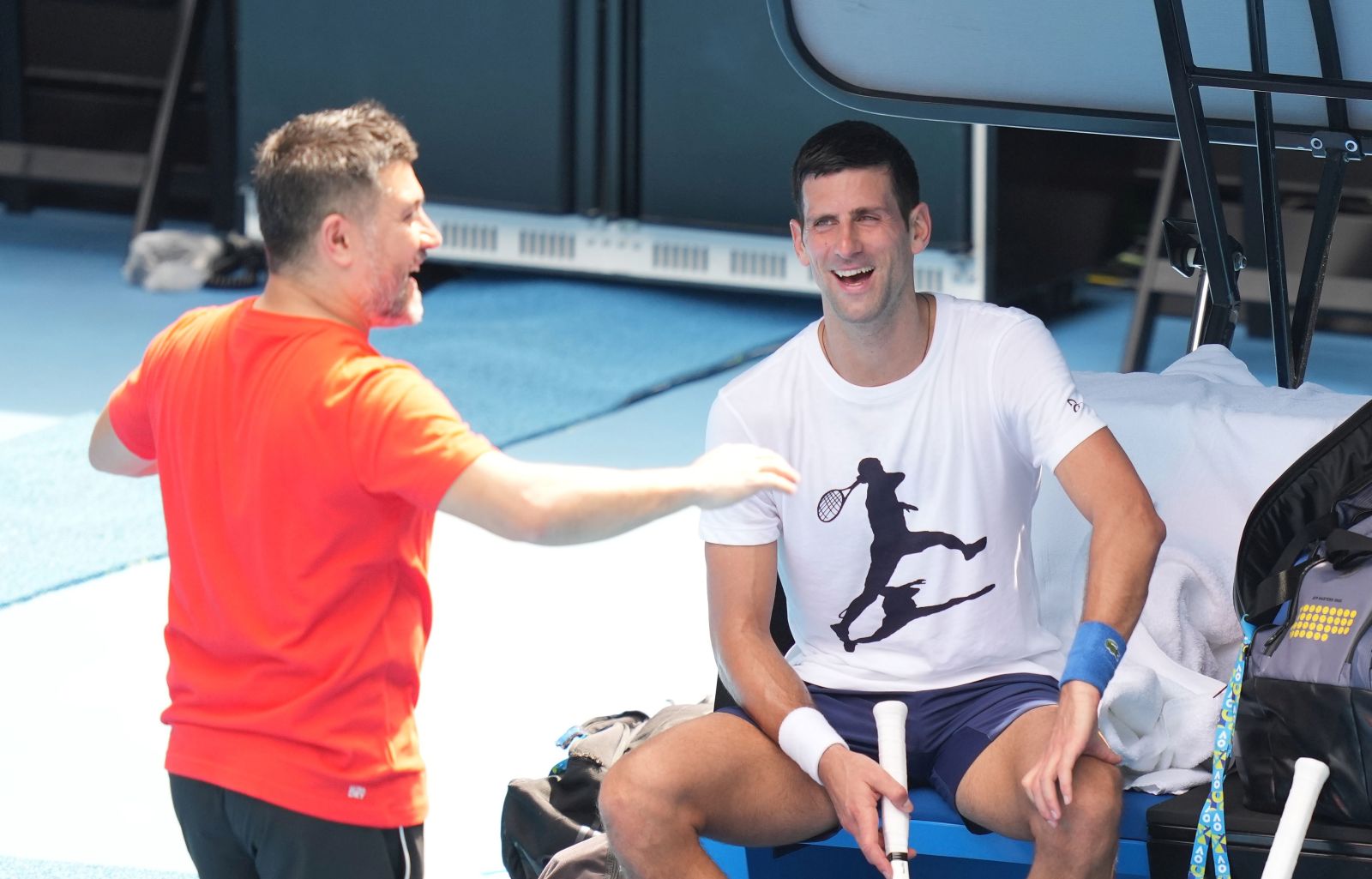 epa09678333 A handout photo made available by Tennis Australia of Novak Djokovic (R) of Serbia and his physiotherapist Ulises Badio during a practice session ahead of the Australian Open, Melbourne Park, in Melbourne, Australia 11 January 2022.  EPA/SCOTT BARBOUR / Tennis Australia HANDOUT  HANDOUT EDITORIAL USE ONLY/NO SALES/NO ARCHIVES