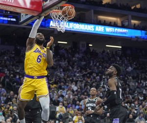 epa09681766 Los Angeles Lakers forward LeBron James (L) dunks the ball for two points as Sacramento Kings forward Chimezie Metu (R) looks on during the first half of their NBA game at Golden 1 Center in Sacramento, California, USA, 12 January 2022.  EPA/JOHN G. MABANGLO  SHUTTERSTOCK OUT