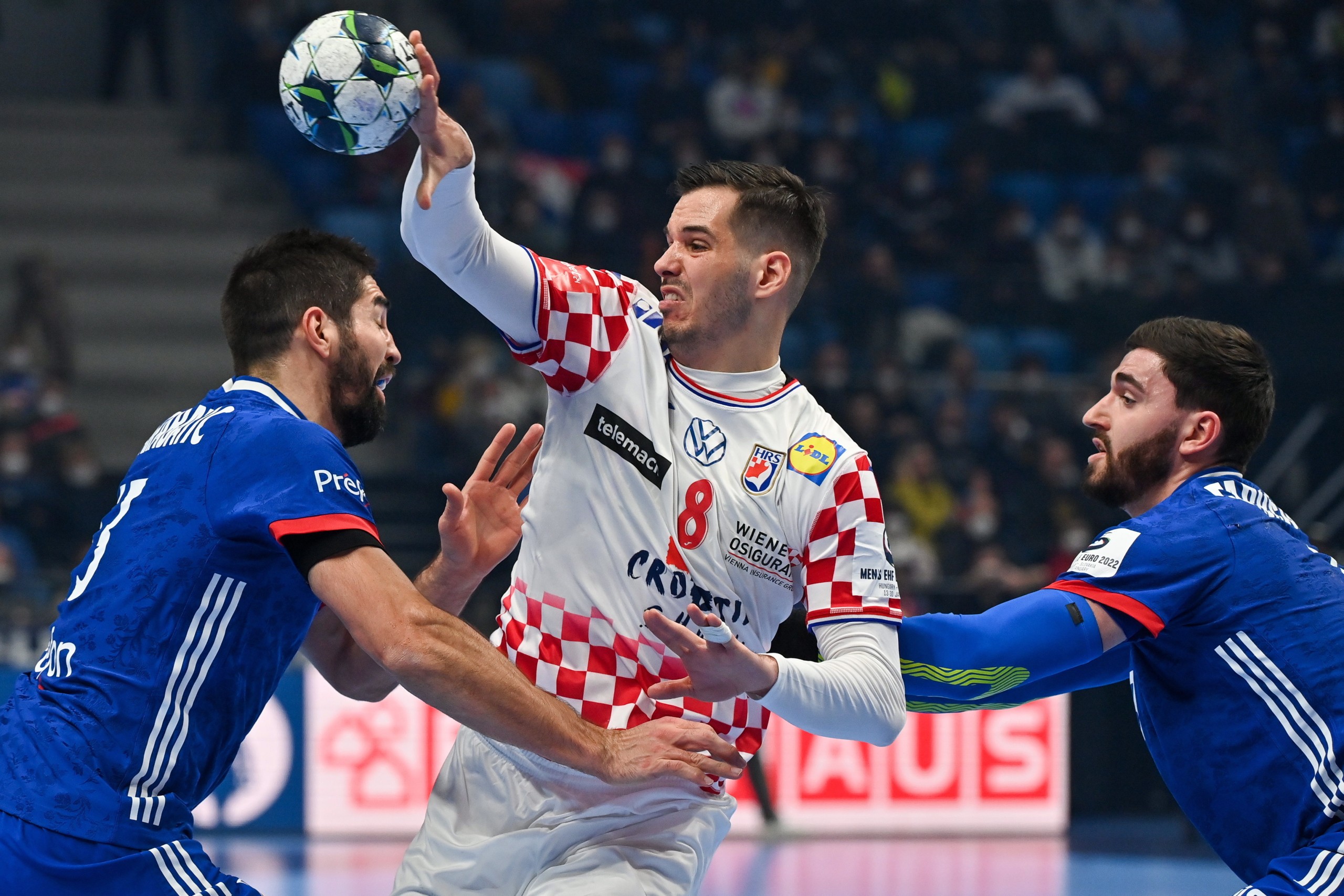 epa09683801 Ante Gadza (C) of Croatia in action against Nikola Karabatic (L) and Ludovic Fabregas of France during the Men's European Handball Championship preliminary round match between France and Croatia at  Pick Arena in Szeged, Hungary, 13 January 2022.  EPA/Tibor Illyes HUNGARY OUT