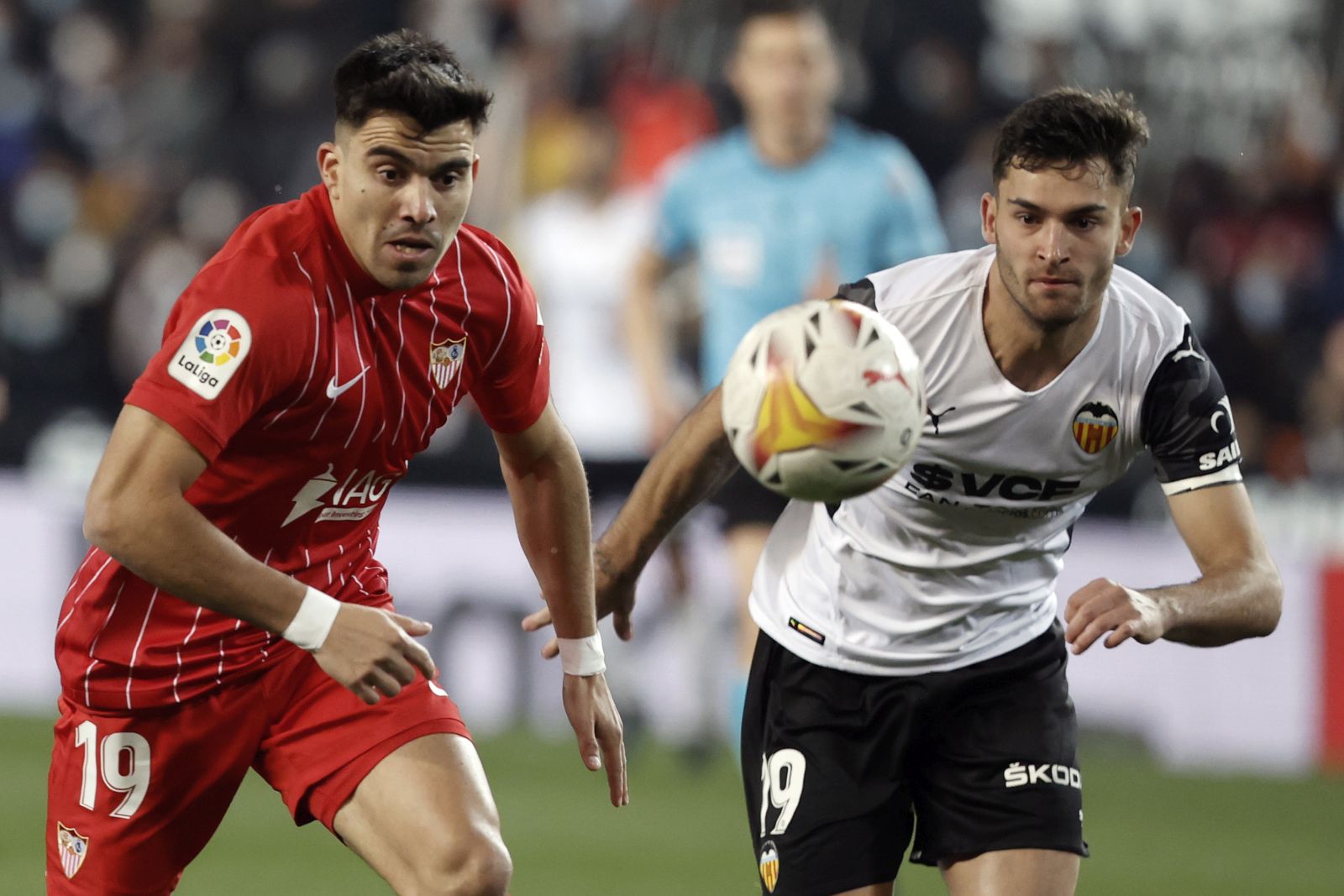 epa09695768 Valencia's Hugo Duro (R) in action against Sevilla's Marcos Acuna (L) during the Spanish LaLiga soccer match between Valencia CF and Sevilla FC in Valencia, eastern Spain, 19 January 2022.  EPA/Kai Foersterling