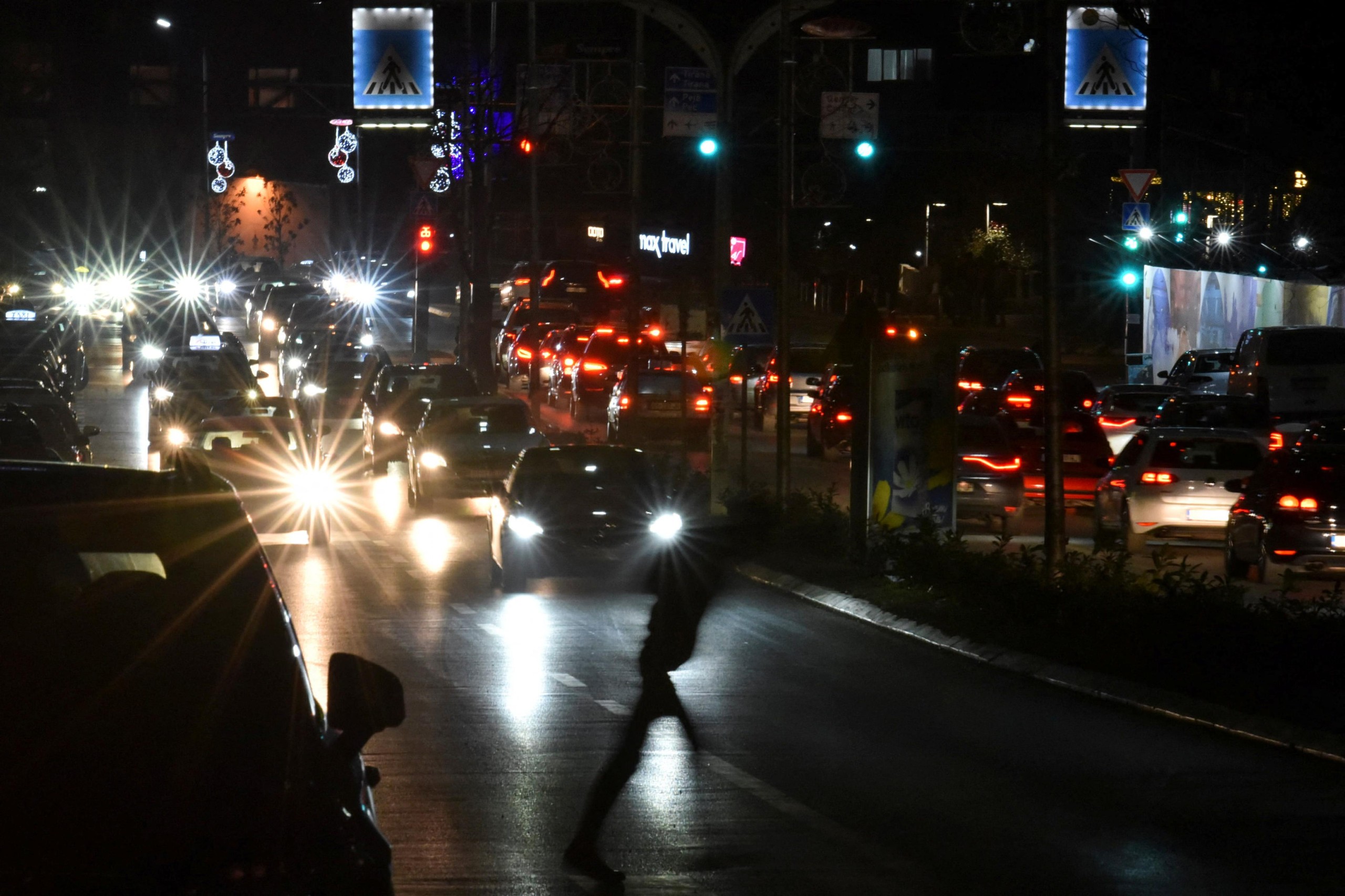 A pedestrian is pictured crossing the street during the power cut in Pristina, Kosovo, December 27, 2021. Picture taken December 27, 2021. REUTERS/Laura Hasani Photo: LAURA HASANI/REUTERS