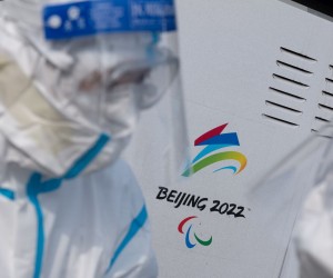 epa09719672 Staffs wearing protective gear talk next an Olympics sign at the Beijing International Airport in China, 31 January 2022. The Beijing 2022 Winter Olympics is scheduled to start on 04 February 2022.  EPA/JEON HEON-KYUN