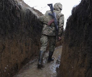 epa09741653 A Ukrainian serviceman checks the situation at the positions on a front line near Zolote village, not far from where pro-Russian militants controlled city of Luhansk, Ukraine, 09 February 2022 amid escalation on the Ukraine-Russia border.  EPA/STANISLAV KOZLIUK