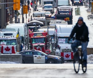 epa09741756 A person cycles past a roadblock as truckers continue to protest the vaccine mandates in in downtown Ottawa, Ontario, Canada, 09 February 2022. Since 29 January 2022, truckers are protesting against the mandate by the Canadian government that truckers be vaccinated against COVID-19 to return to Canada, and was joined by other opponents of the Canadian Prime Minister. A state of emergency was declared in the city of Ottawa on 06 February 2022 and policemen from Ottawa city, Ontario, and the Federal Royal Canadian Mounted Police (RCMP) are deployed.  EPA/ANDRE PICHETTE