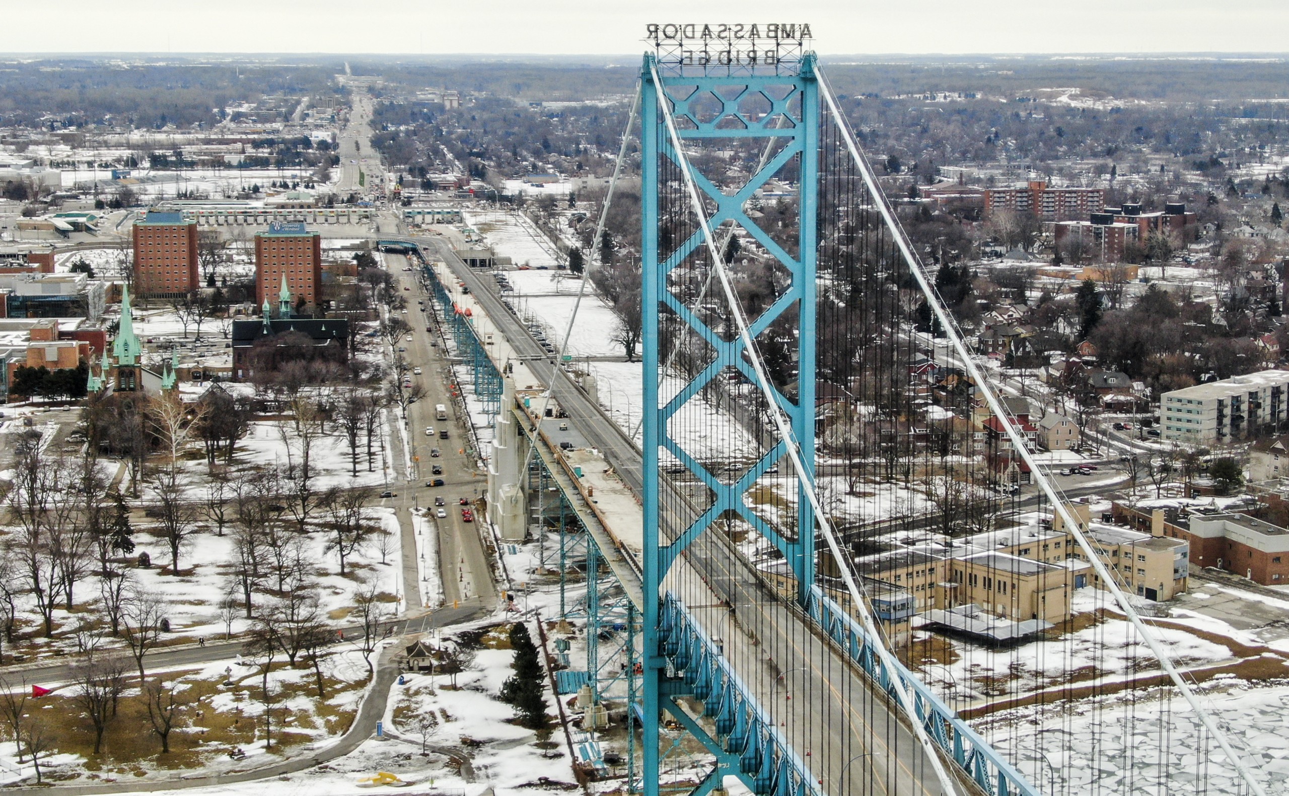 epa09745236 An aerial photo made with a drone looking towards Canada and Canadian Customs shows the closed Ambassador Bridge over the Detroit River that links the US and Canada between Windsor, Ontario, Canada and Detroit, Michigan, USA, 10 February 2022. The bridge, a vital link where 25 percent of goods between the two countries passes on an estimated 10,000 trucks each day, has been shut down by truckers protesting vaccine mandates in Canada.  EPA/TANNEN MAURY