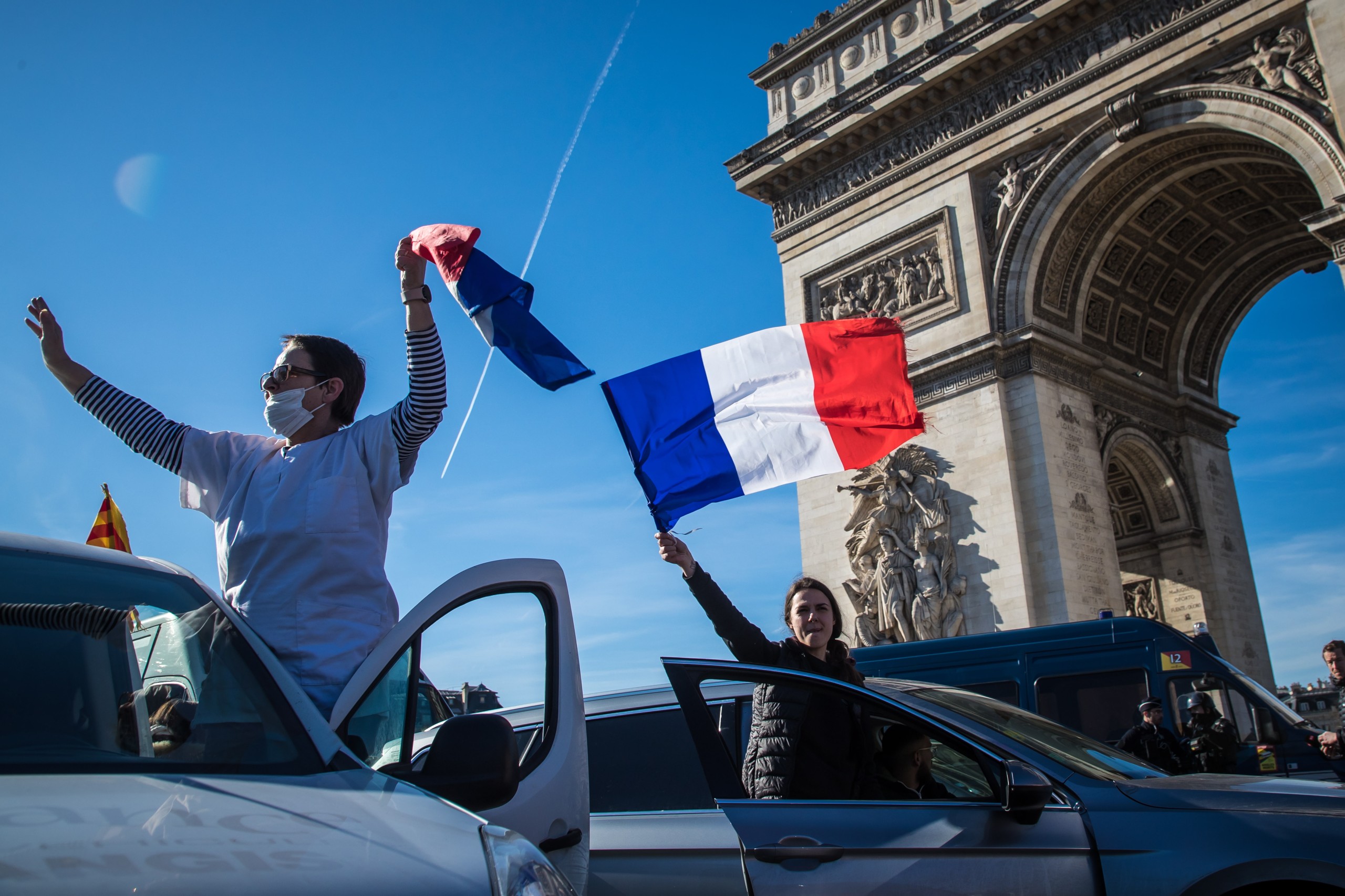 epa09749902 Participants in a so-called 'Freedom Convoy' stand on their cars and wave flags as they are trying to block the traffic on Champs Elysee in Paris, France, 12 February 2022. Paris police have prohibited the convoy, as announced by the capital's prefect on 10 February. A series of convoy demonstrations has been taking place in France to call for the lifting of all Covid-19-related restrictions and mandates, in light of the ongoing protest in Canada, where truck drivers have been rallying against the government-imposed mandatory Covid-19 vaccine to enter the country.  EPA/CHRISTOPHE PETIT TESSON