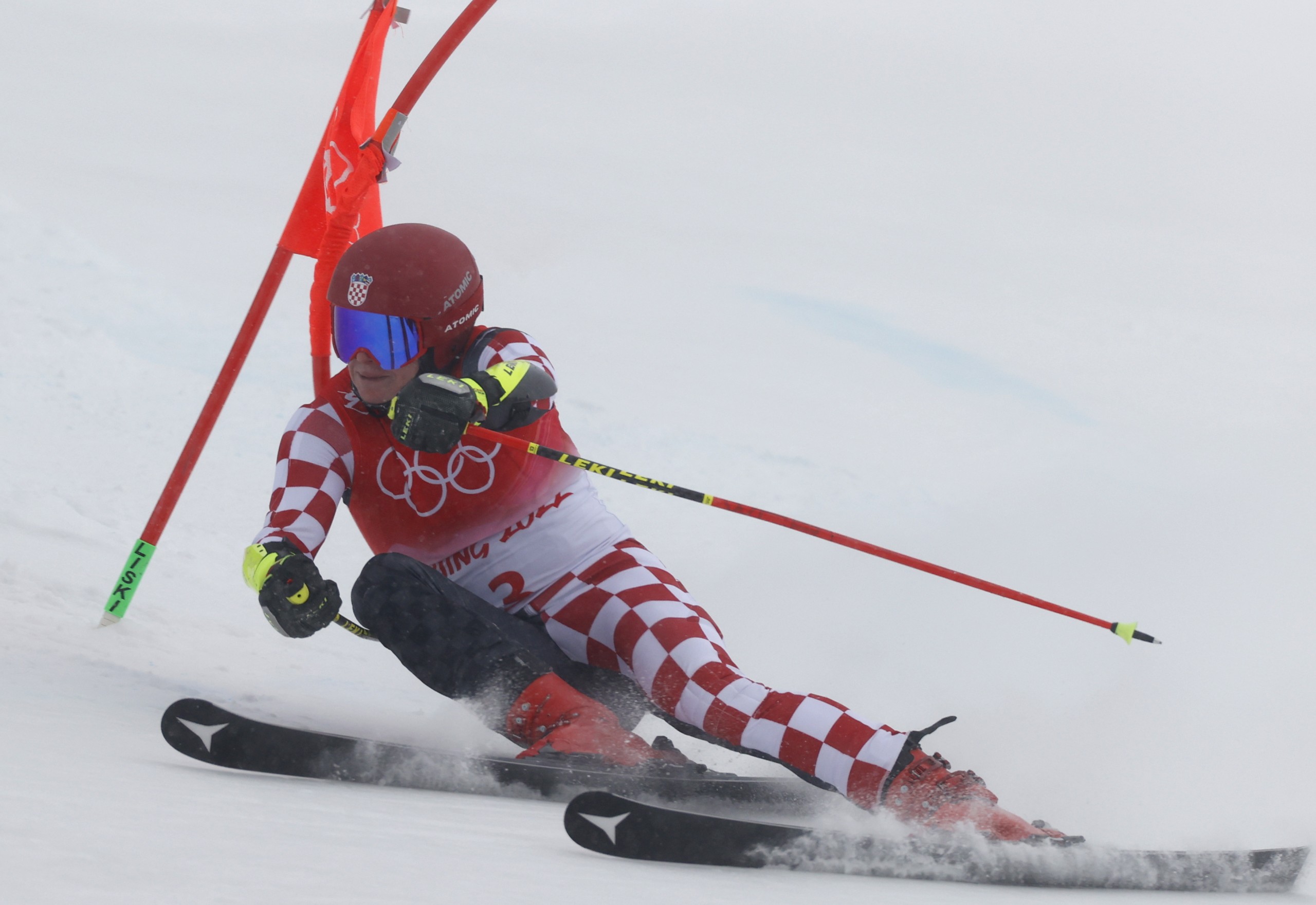 epa09751634 Filip Zubcic of Croatia clears a gate during the second run of the Men's Giant Slalom race of the Alpine Skiing events of the Beijing 2022 Olympic Games at the Yanqing National Alpine Ski Centre Skiing, Beijing municipality, China, 13 February 2022.  EPA/GUILLAUME HORCAJUELO