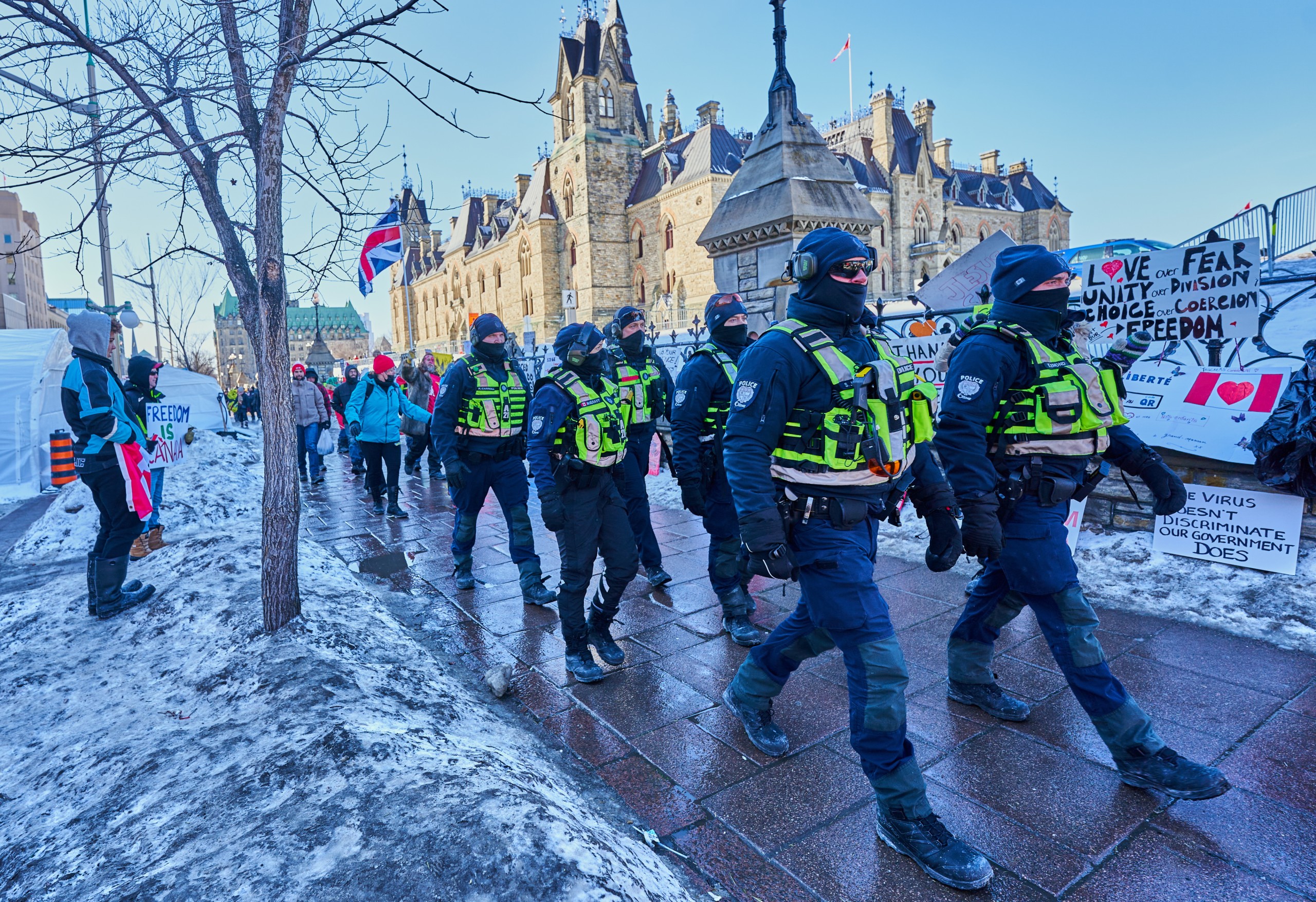 epa09754111 Policemen patrol near Parliament hill as truckers continue to protest in Ottawa, Canada, 13 February 2022. Truckers continue their protest against the mandate by the Canadian government for mandatory vaccines against COVID-19 to be able to return to Canada. A state of emergency was declared in the city of Ottawa on 06 February 2022 and policemen from Ottawa city, Ontario, and the Federal Royal Canadian Mounted Police (RCMP) are deployed.  EPA/VALERIE BLUM