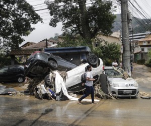 epa09763047 Cars have been turned over amid damages caused by the heavy rains that affect the city of Petropolis, RJ, Brazil, 16 February 2022. At least 38 people have died in Petropolis in floods following heavy rains.  EPA/Antonio Lacerda