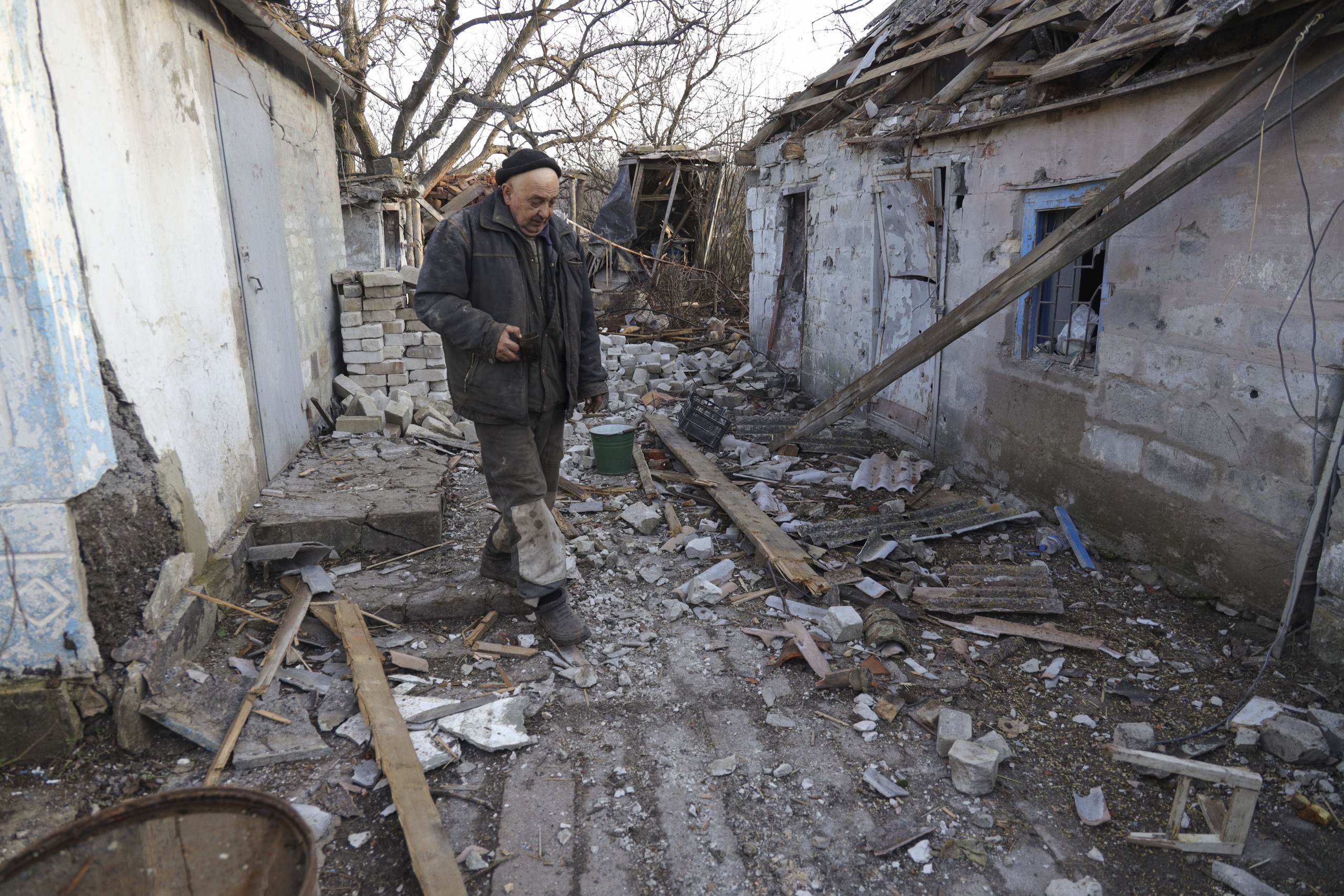 epa09774802 Local resident Valery walks around a damaged homestead as a result of shelling in Tamarchuk village near Marinka not far from pro-Russian militants controlled city of Donetsk, Ukraine, 20 February 2022. Tamarchuk only has 15 local residents and it is placed in a ‘grey zone’ between Ukraine and Pro-Russian militants. There are no Ukraine troops in the village but it has been getting shelled by militants for three days in a row. The last shelling was on 9 am on 20 February.  EPA/STANISLAV KOZLIUK  ATTENTION: This Image is part of a PHOTO SET
