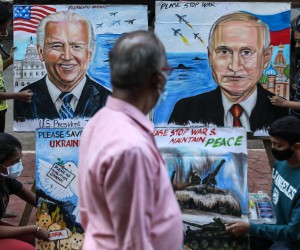 epa09775609 A man walks past students of the Gurukul School of Art painting portraits of US President Joe Biden and Russian President Vladimir Putin with a message wishing peace between Ukraine and Russia, in Mumbai, India, 21 February 2022. NATO and the White House have dismissed Russian claims that they are drawing down troops on the Ukrainian border.  EPA/DIVYAKANT SOLANKI