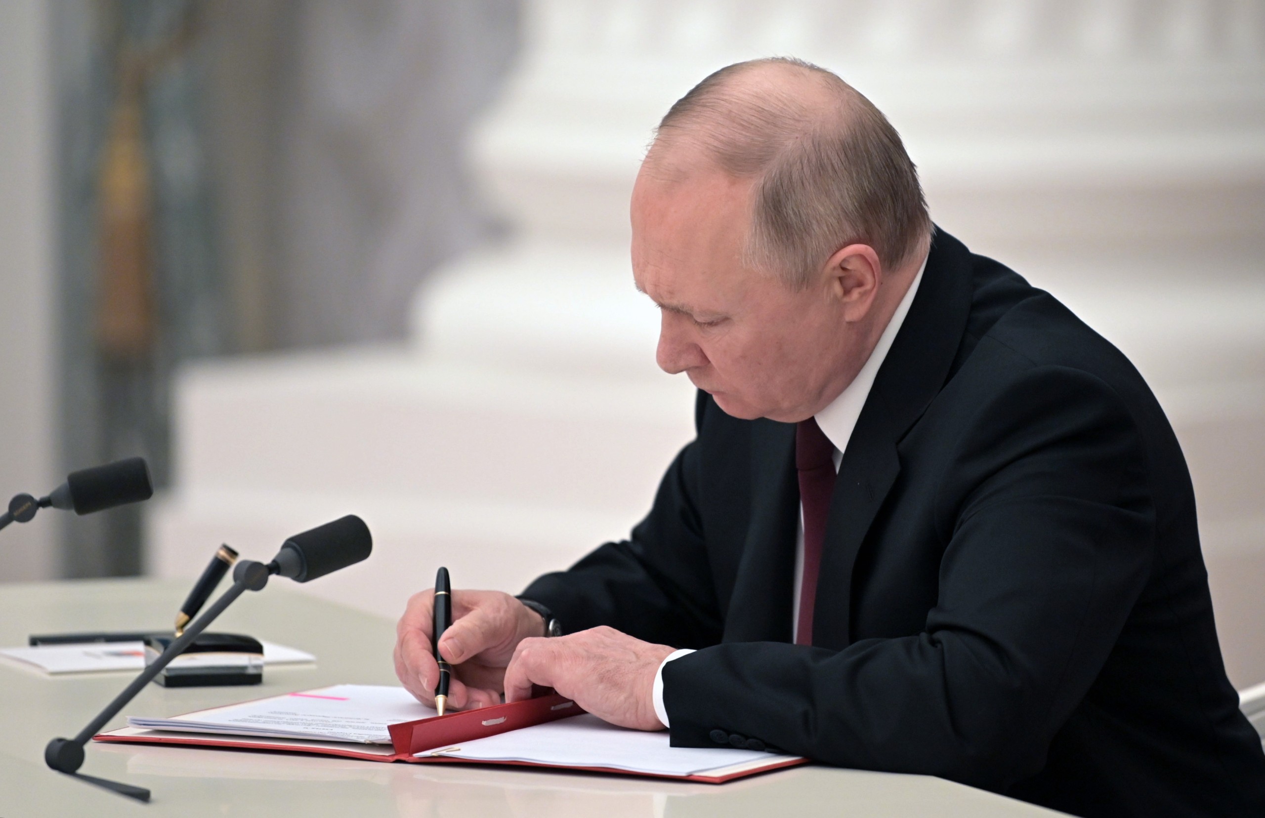 epa09776137 Russian President Vladimir Putin signs decrees on the recognition of the self-proclaimed Donetsk People's Republic (DPR) and the Luhansk People's Republic (LPR) in Moscow Kremlin in Moscow, Russia, 21 February 2022. The heads of the self-proclaimed Donetsk People's Republic (DPR) and the Luhansk People's Republic (LPR) asked the President of Russia to recognize the self-proclaimed republics. This issue was discussed at a meeting of the Security Council of the Russian Federation, Vladimir Putin appealed to the Federal Assembly of the Russian Federation to ratify the treaty of friendship and mutual assistance with the DPR-LPR. Putin  signed decrees on the recognition of the self-proclaimed Donetsk People's Republic (DPR) and the Luhansk People's Republic (LPR).  EPA/ALEKSEY NIKOLSKYI/SPUTNIK/KREMLIN POOL / POOL
