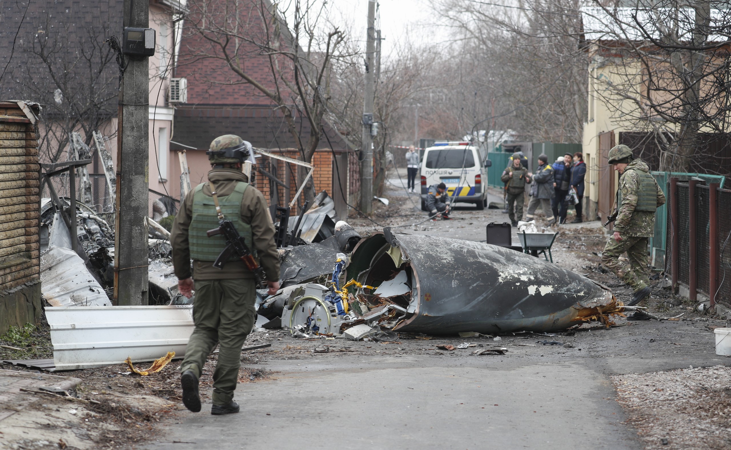 epa09783634 Soldiers look at the debris of a military plane that was shot down overnight in Kiev, Ukraine, 25 February 2022. Russian troops entered Ukraine on 24 February prompting the country's president to declare martial law.  EPA/SERGEY DOLZHENKO