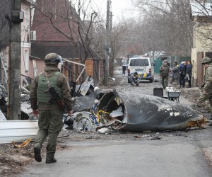 epa09783634 Soldiers look at the debris of a military plane that was shot down overnight in Kiev, Ukraine, 25 February 2022. Russian troops entered Ukraine on 24 February prompting the country's president to declare martial law.  EPA/SERGEY DOLZHENKO