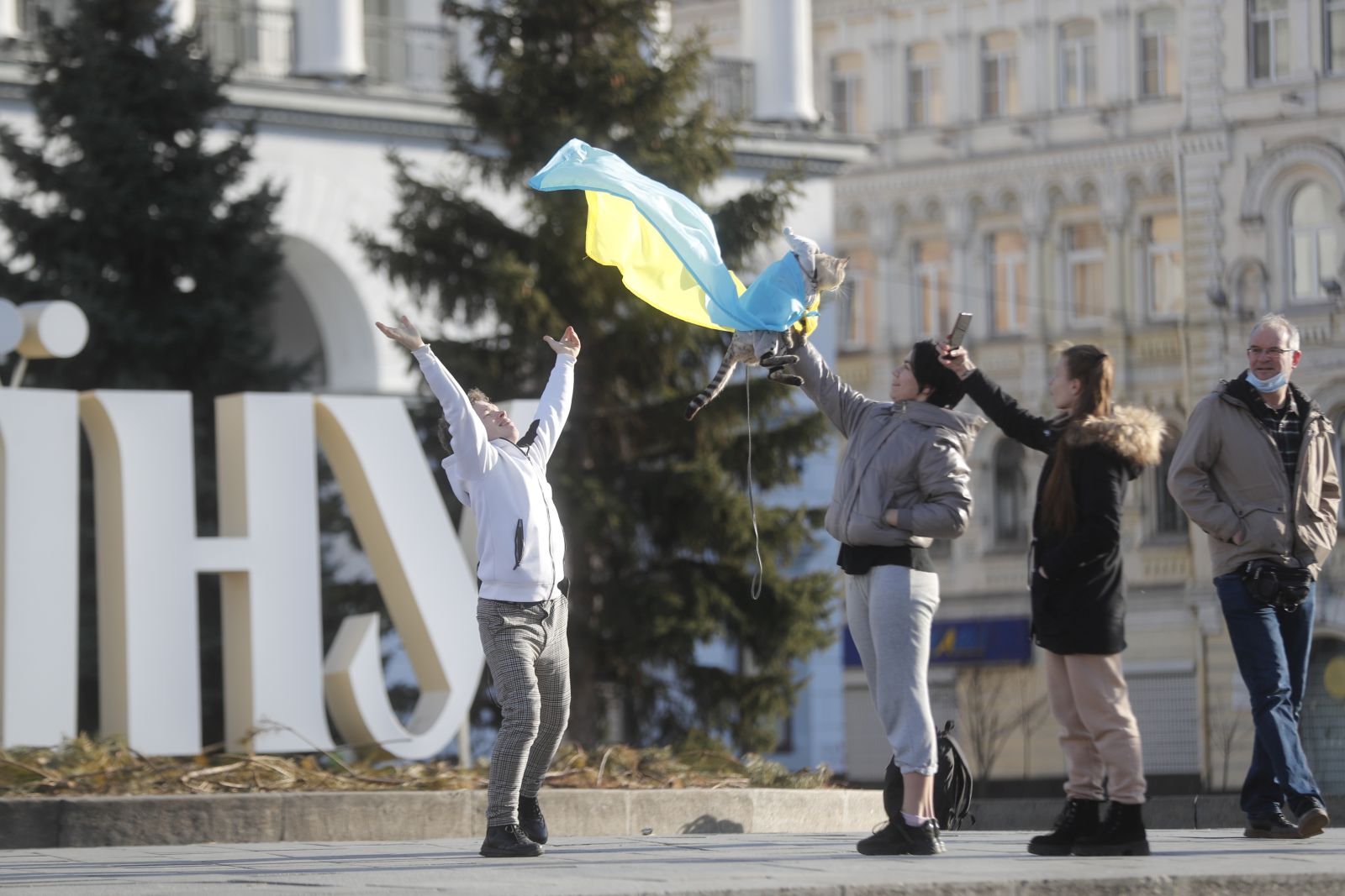 epa09786835 People take photos of a cat wrapped in a Ukrainian flag in Kiev, Ukraine, 26 February 2022. Russian troops launched a major military operation on Ukraine on 24 February, after weeks of intense diplomacy and the imposition of Western sanctions on Russia aimed at preventing an armed conflict in Ukraine. Martial law was introduced in Ukraine, with explosions heard in many cities, including Kiev.  EPA/ZURAB KURTSIKIDZE