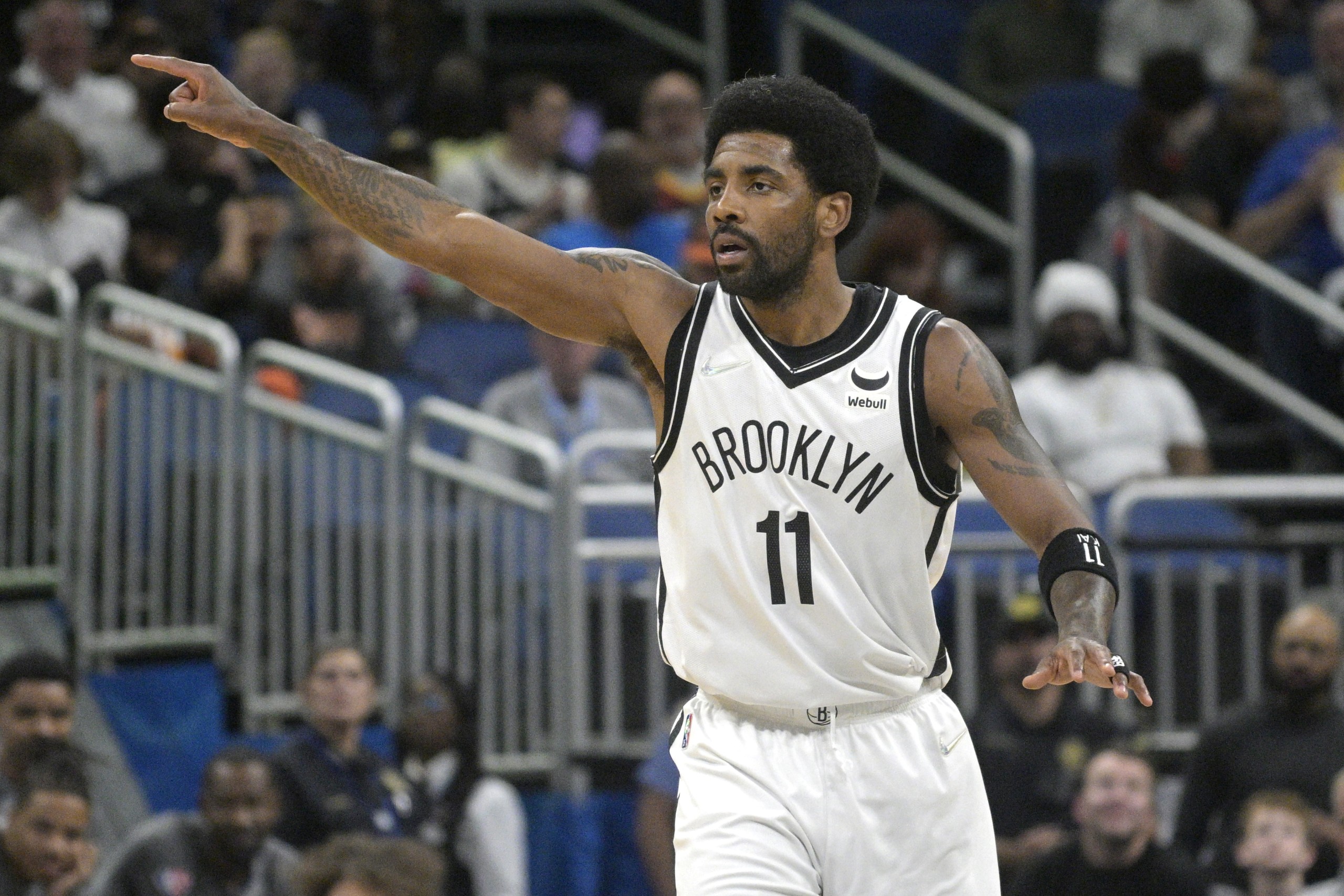 Brooklyn Nets guard Kyrie Irving (11) acknowledges a teammate after scoring a 3-pointer during the first half of an NBA basketball game against the Orlando Magic, Tuesday, March 15, 2022, in Orlando, Fla. (AP Photo/Phelan M. Ebenhack)