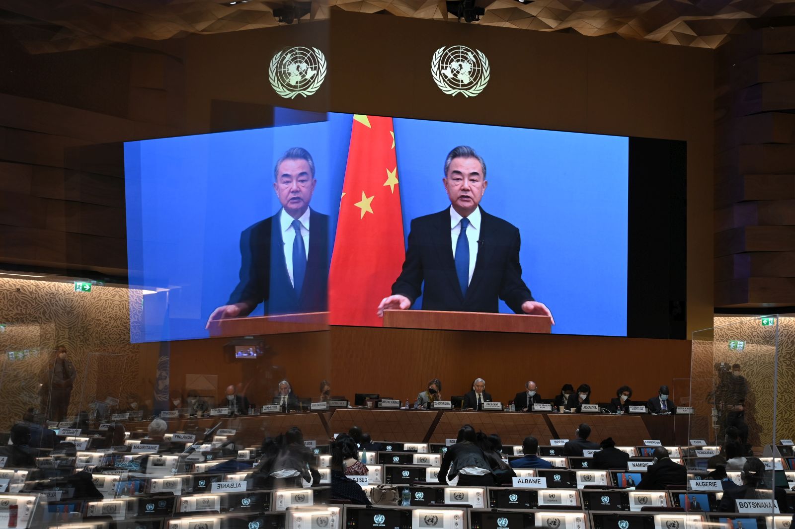 epa09791298 Chinese Foreign minister Wang Yi appears on a screen as he delivers a remote speech at the opening of the 49th session of the UN Human Rights Council in Geneva, Switzerland,  28 February 2022. The UN Human Rights Council voted to hold an urgent debate about Russia's invasion of Ukraine at Kyiv's request, amid widespread international condemnation of Russia's attack.  EPA/FABRICE COFFRINI / POOL