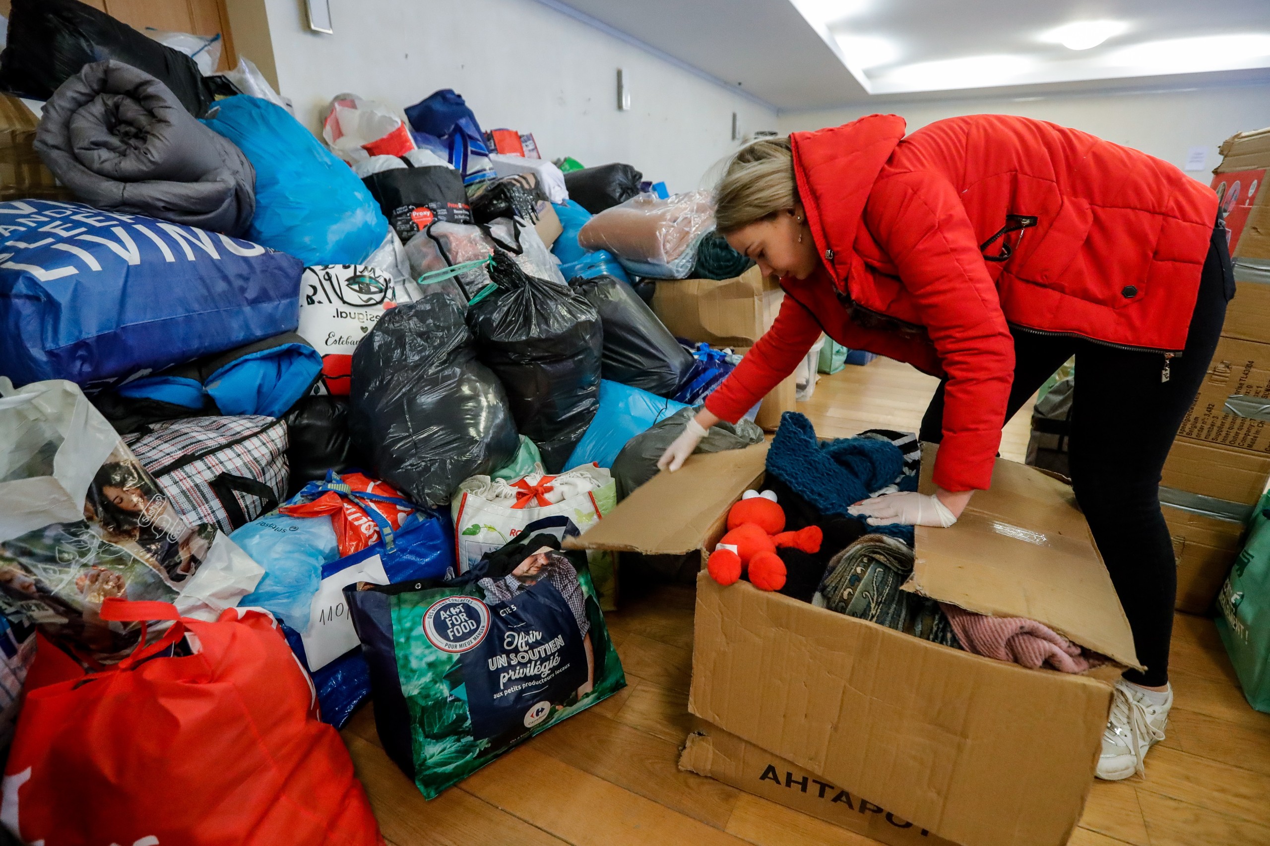 epa09798830 A Ukrainian volunteer sorts humanitarian packages, arranged by the type of product, destined to help the Ukrainian population, at the Embassy of Ukraine in Brussels, Belgium, 03 March 2022. Given the influx of people donating humanitarian packages, Ukraine's embassy in Brussels is no longer able to collect all the donations. A new collection point has been opened at Plais 11 of the Brussels Expo. Only military equipment can still be received at the embassy.  EPA/STEPHANIE LECOCQ
