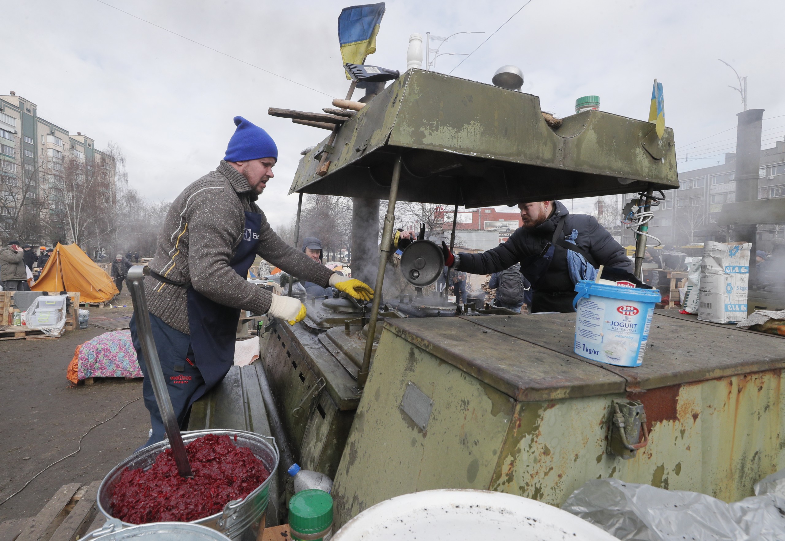 epa09805954 Ukrainians cook food for territorial defense members in their camp near one of blockposts in Kyiv (Kiev), Ukraine, 06 March 2022. Russian troops entered Ukraine on 24 February leading to a massive exodus of Ukrainians to neighboring countries as well as internal displacements.  EPA/SERGEY DOLZHENKO