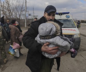 epa09812947 Ukrainian man carries his child as he flees from the frontline town of Irpin, Kyiv (Kiev) region, Ukraine, 09 March 2022. Irpin, the town which is located near Kyiv city had heavy fighting for almost a week between Ukrainian and Russian militaries forcing thousands of people to escape from the town.  EPA/STRINGER