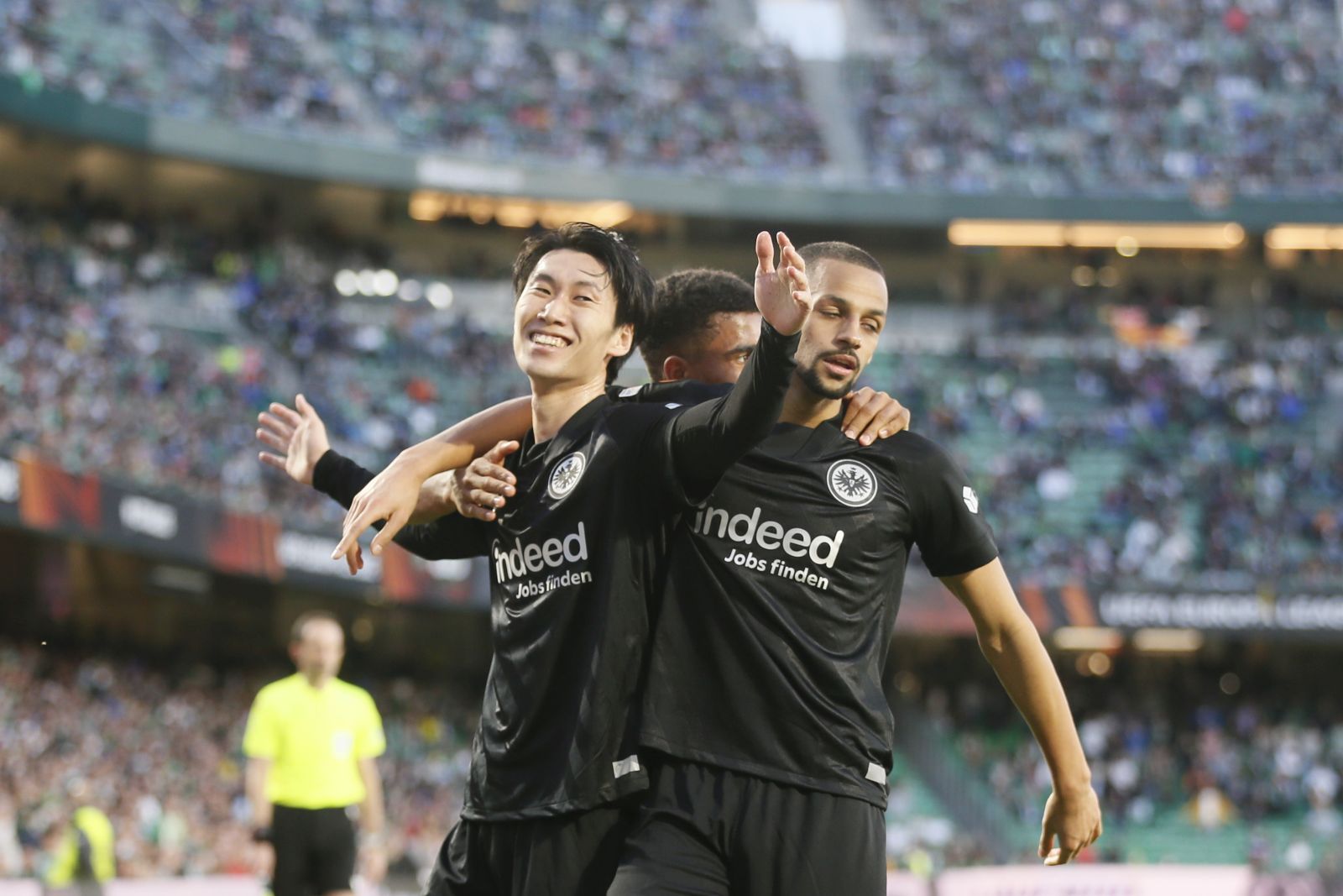 epa09813158 Eintracht's Daichi Kamada (L) celebrates with teammates after scoring the 2-1 lead during the UEFA Europa League round of 16, first leg soccer match between Real Betis and Eintracht Frankfurt in Seville, southern Spain, 09 March 2022.  EPA/Jose Manuel Vidal