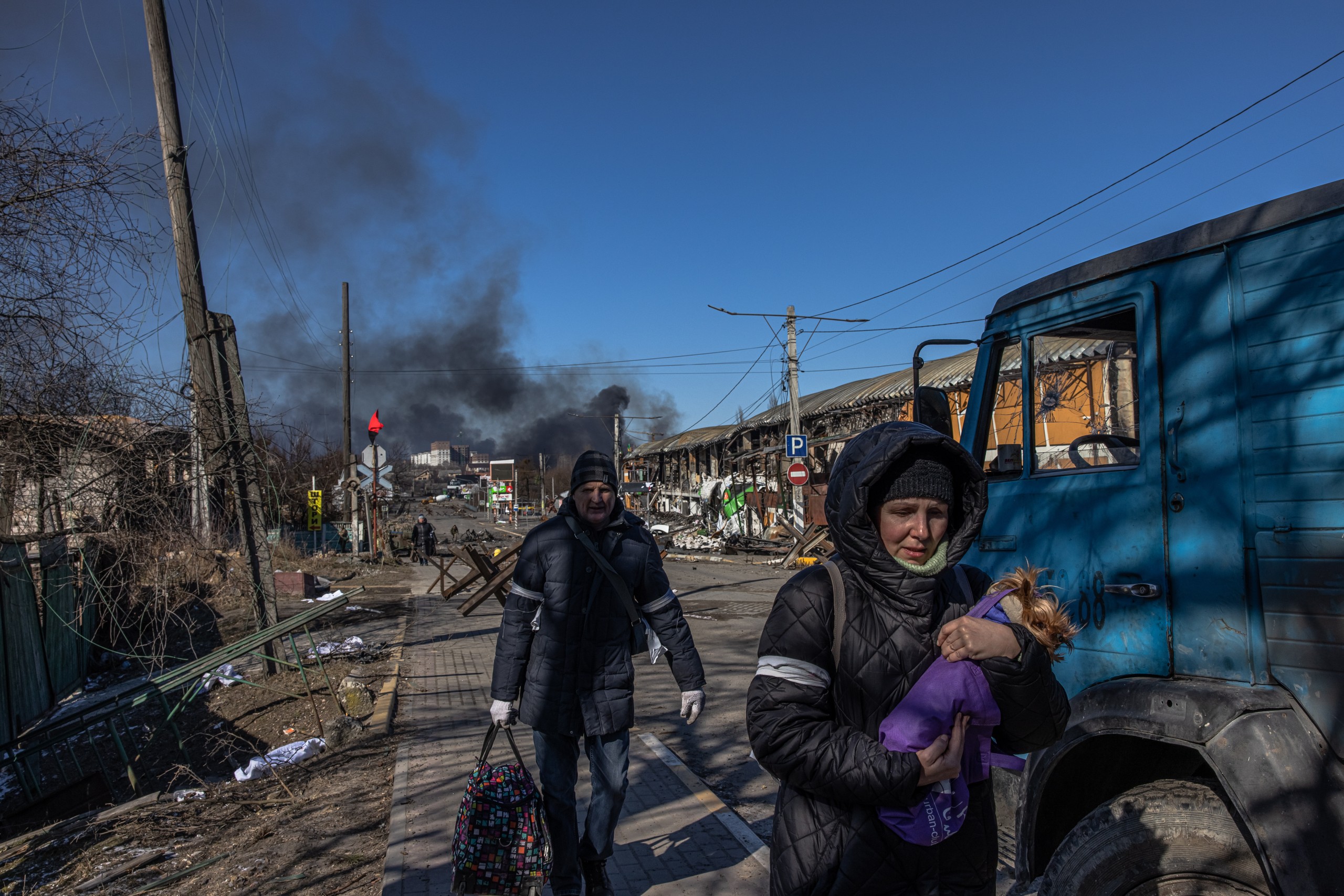 epa09815740 Residents coming from Bucha town, which is currently controlled by the Russian military, walk with luggage past the Ukrainian checkpoint at the frontline in Irpin town, Kyiv (Kiev) region, Ukraine, 10 March 2022. Thousands of residents are feeling Irpin and Bucha, as well as other settlements near Kyiv which were the most affected by the Russian army invasion.  EPA/ROMAN PILIPEY