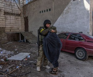 epa09815762 A Ukrainian soldier hugs a woman as residents are evacuated from the frontline town of Irpin, Kyiv (Kiev) region, Ukraine, 10 March 2022. Thousands of residents are feeling Irpin and Bucha, as well as other settlements near Kyiv which were the most affected by the Russian army invasion.  EPA/ROMAN PILIPEY